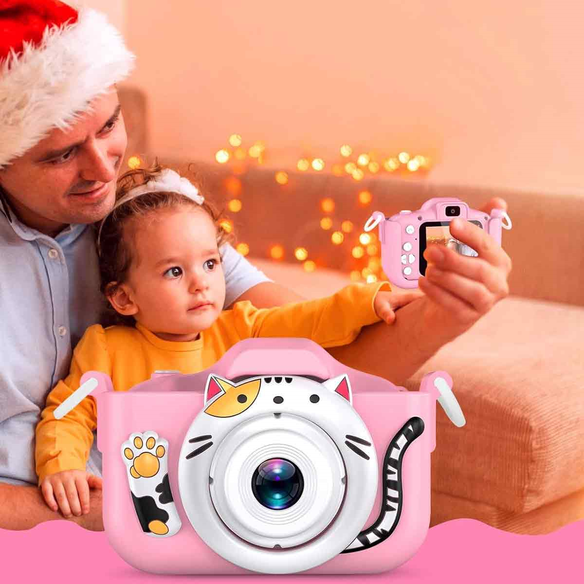 Kind und Mann machen Foto mit rosa Kamera. Weihnachtsmütze im Hintergrund sichtbar.