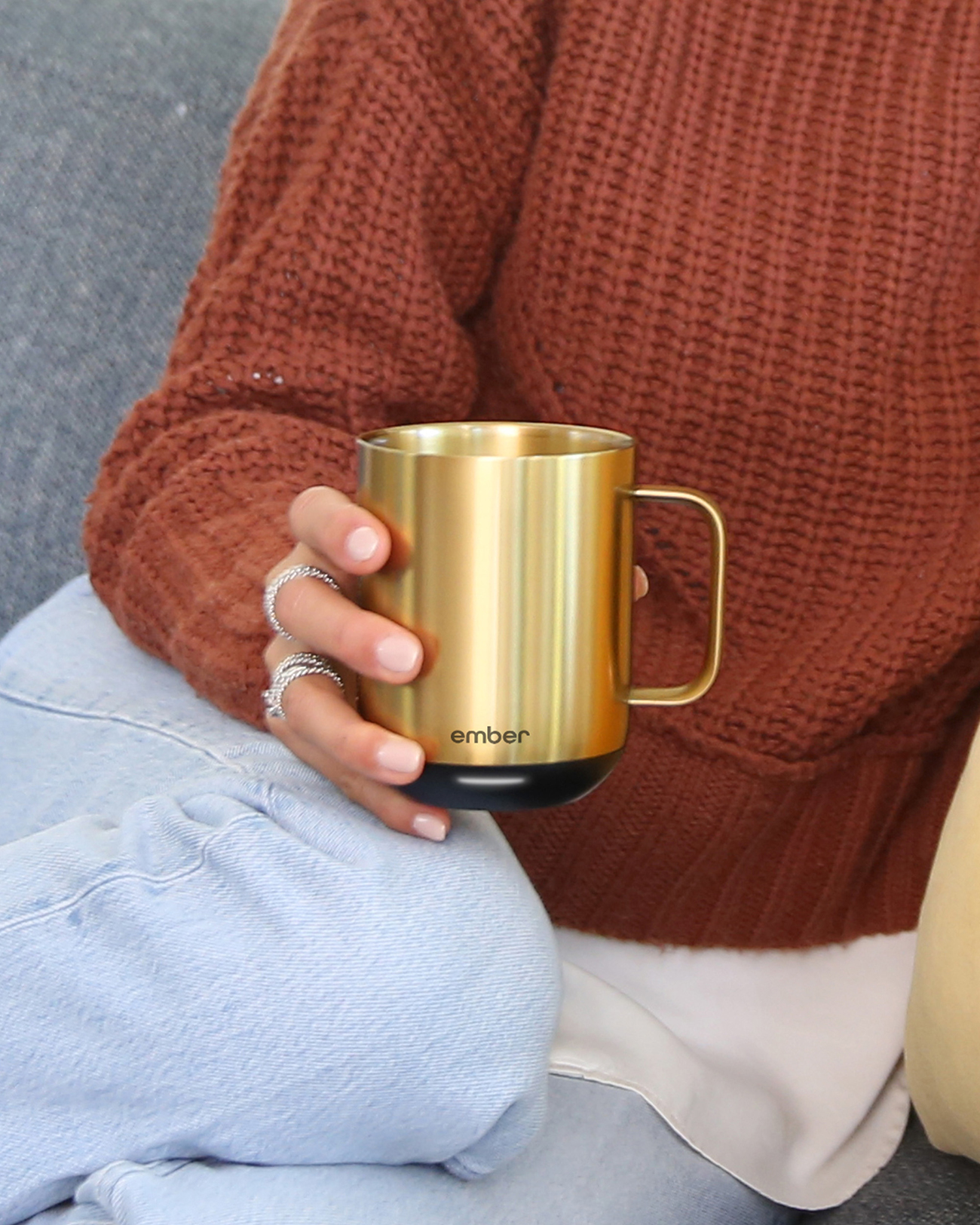Eine Person hält einen goldenen Ember-Becher mit schwarzem Boden.