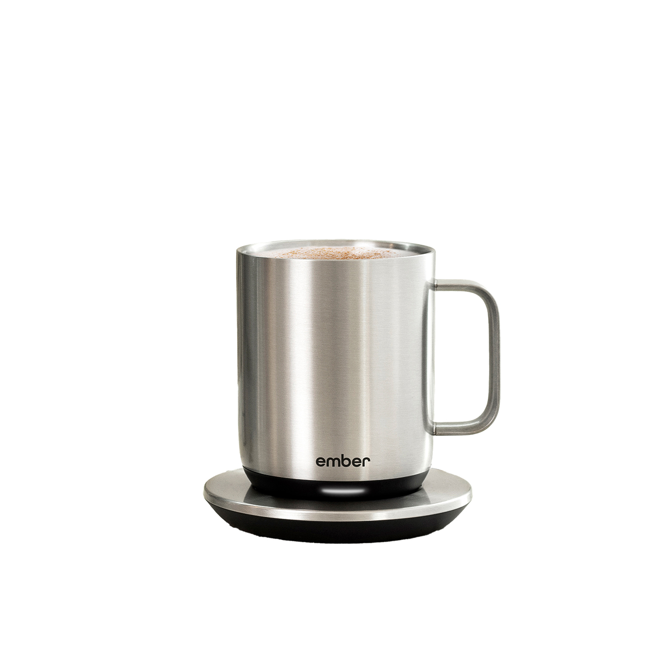 Taza Ember plateada sobre un posavasos negro. La taza tiene asa y contiene líquido con canela.