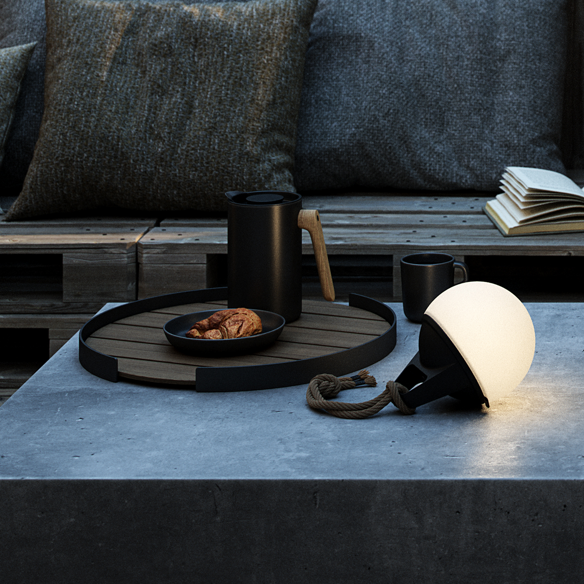Ein Tisch mit Tablett, Lampe, Tasse, Kaffeekanne und Croissant, alles im Freien.