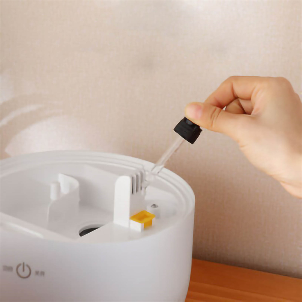 Hand füllt Luftbefeuchter mit einer Pipette.