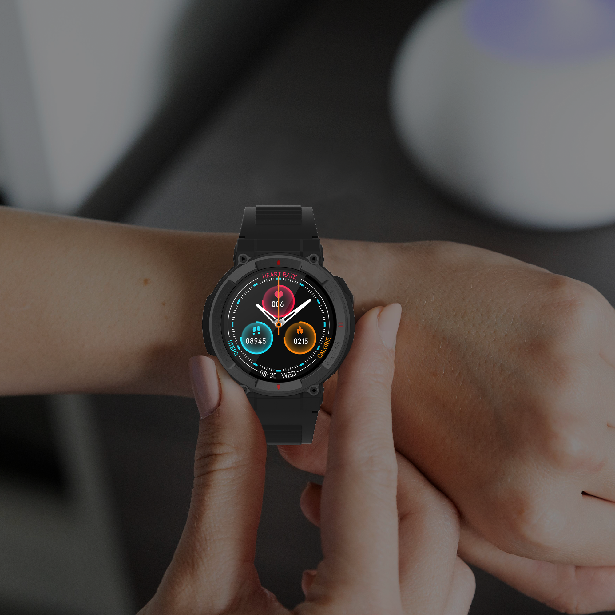 Il polso di una persona con uno smartwatch nero. L'orologio mostra l'ora, la frequenza cardiaca e i passi.