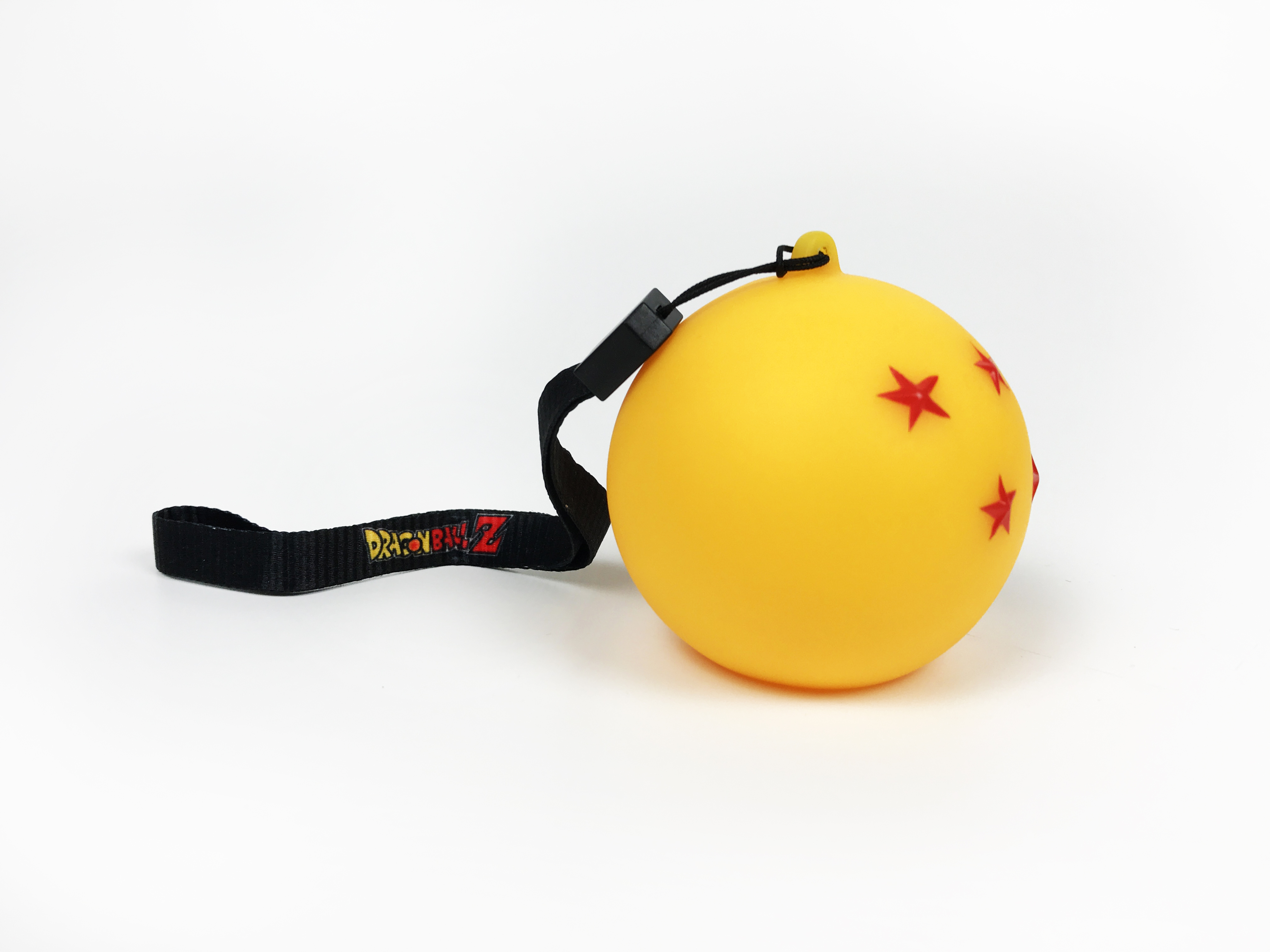 Una Dragon Ball gialla con quattro stelle rosse e un cinturino nero.