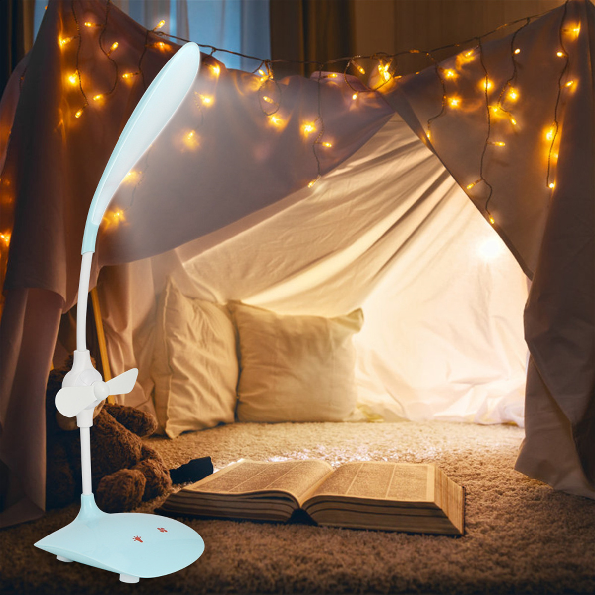 Nachttischlampe mit Ventilator, Buch und Teddybär in einem gemütlichen Zelt mit Lichterketten.