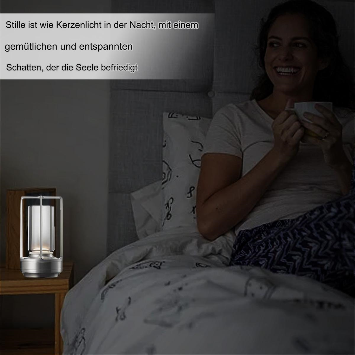 Eine Frau im Bett in der Nähe einer beleuchteten Laterne auf einem Tisch. Über der Laterne befindet sich eine Bildunterschrift auf Deutsch.