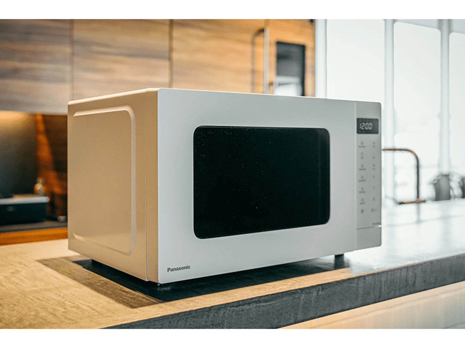 Biała kuchenka mikrofalowa na blacie. Wyświetla czas i ma przyciski po prawej stronie.