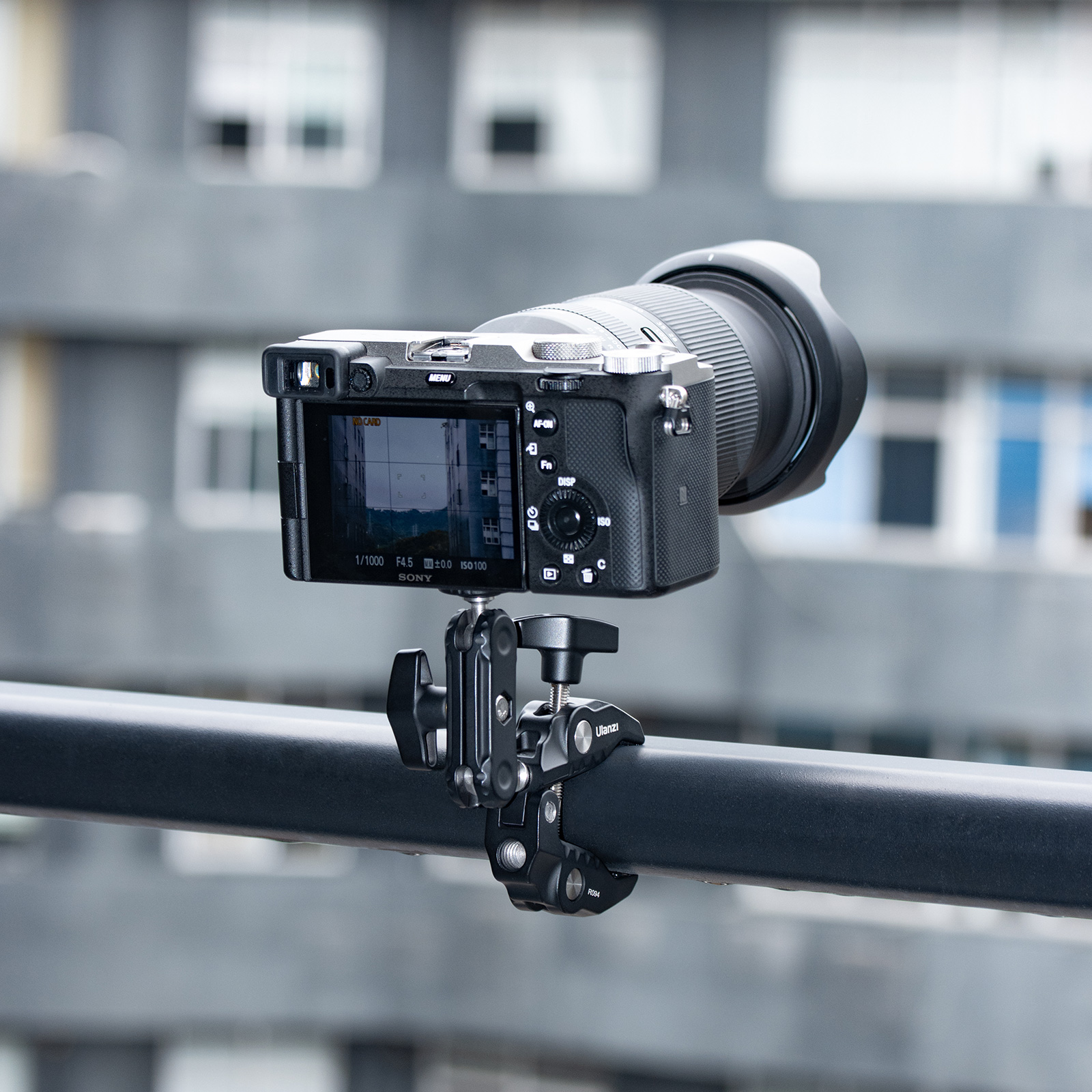 Una fotocamera montata su una ringhiera, con uno sfondo urbano sfocato.