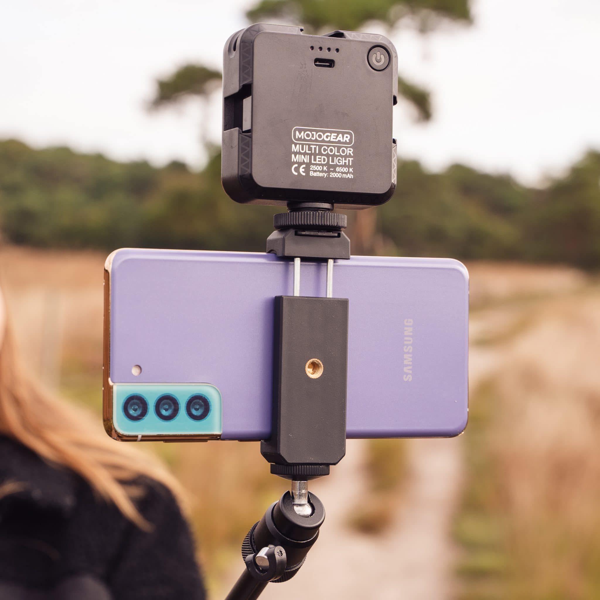 Zwart licht op telefoon bevestigd aan een standaard. Telefoon is paars en heeft camera's.