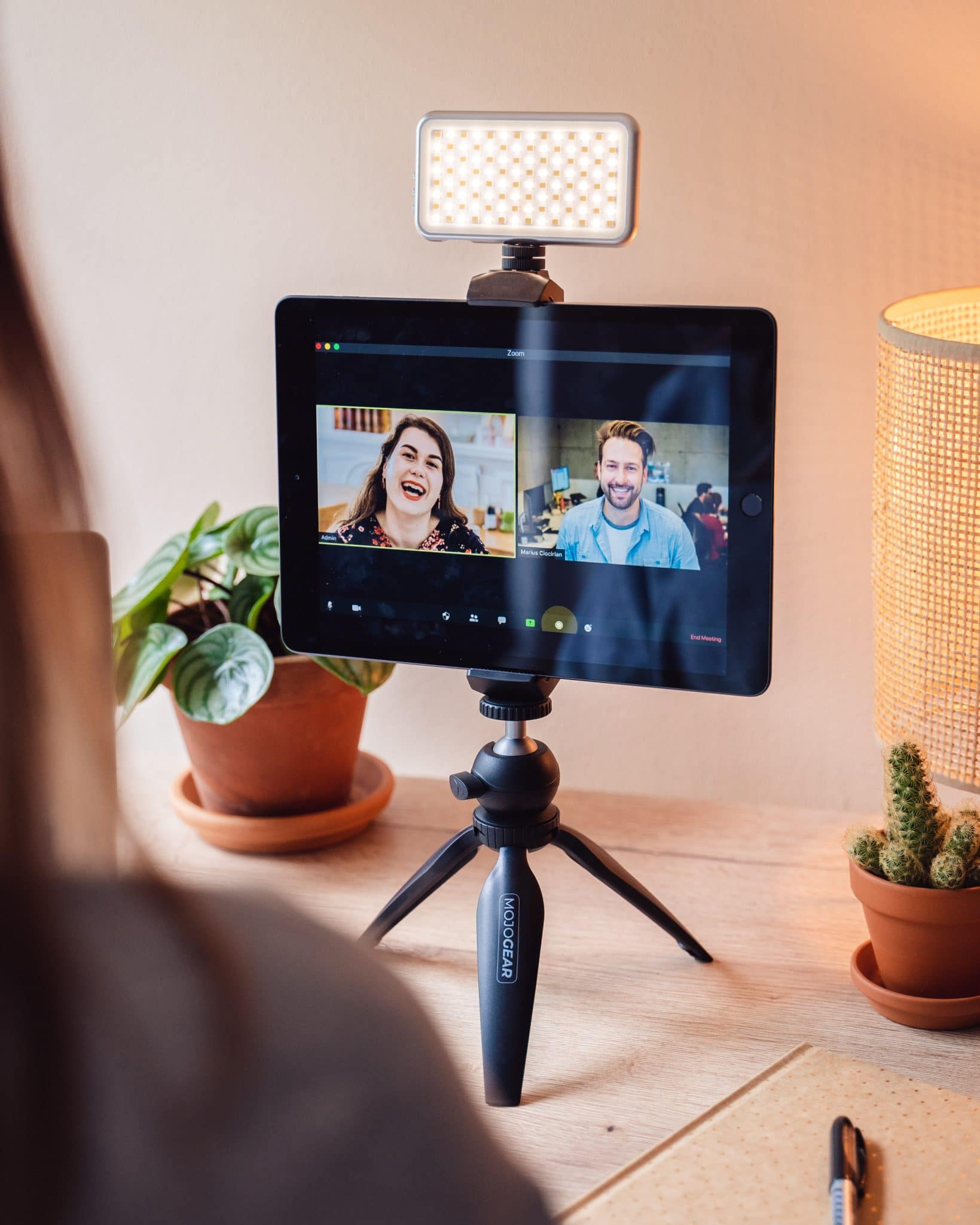 Une tablette sur un trépied affichant un appel vidéo. Une petite lumière est attachée à la tablette.