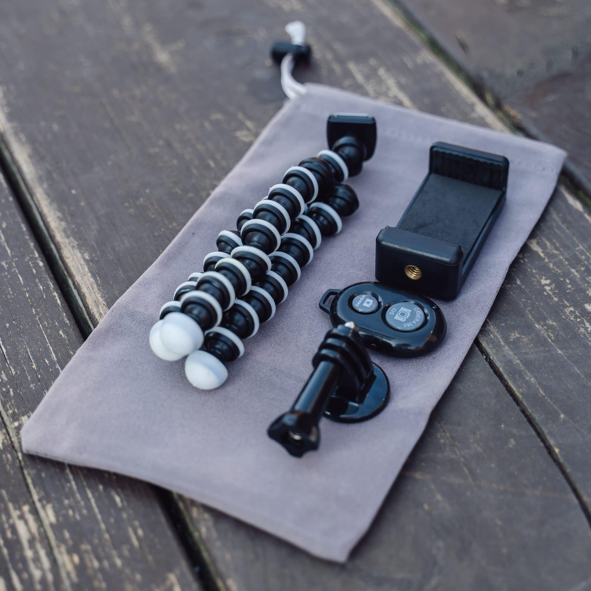 A gray pouch contains a tripod, phone holder, and remote shutter button.