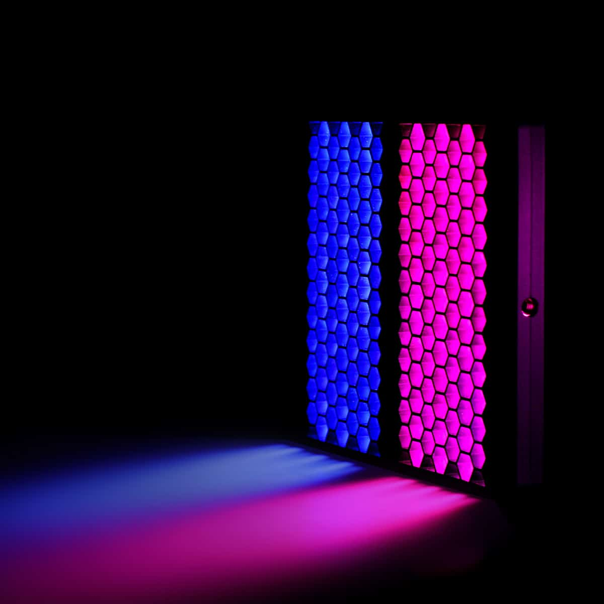 Czarne tło z dwoma panelami świetlnymi. Jeden panel jest niebieski, a drugi różowy, i widać wiązkę światła.
