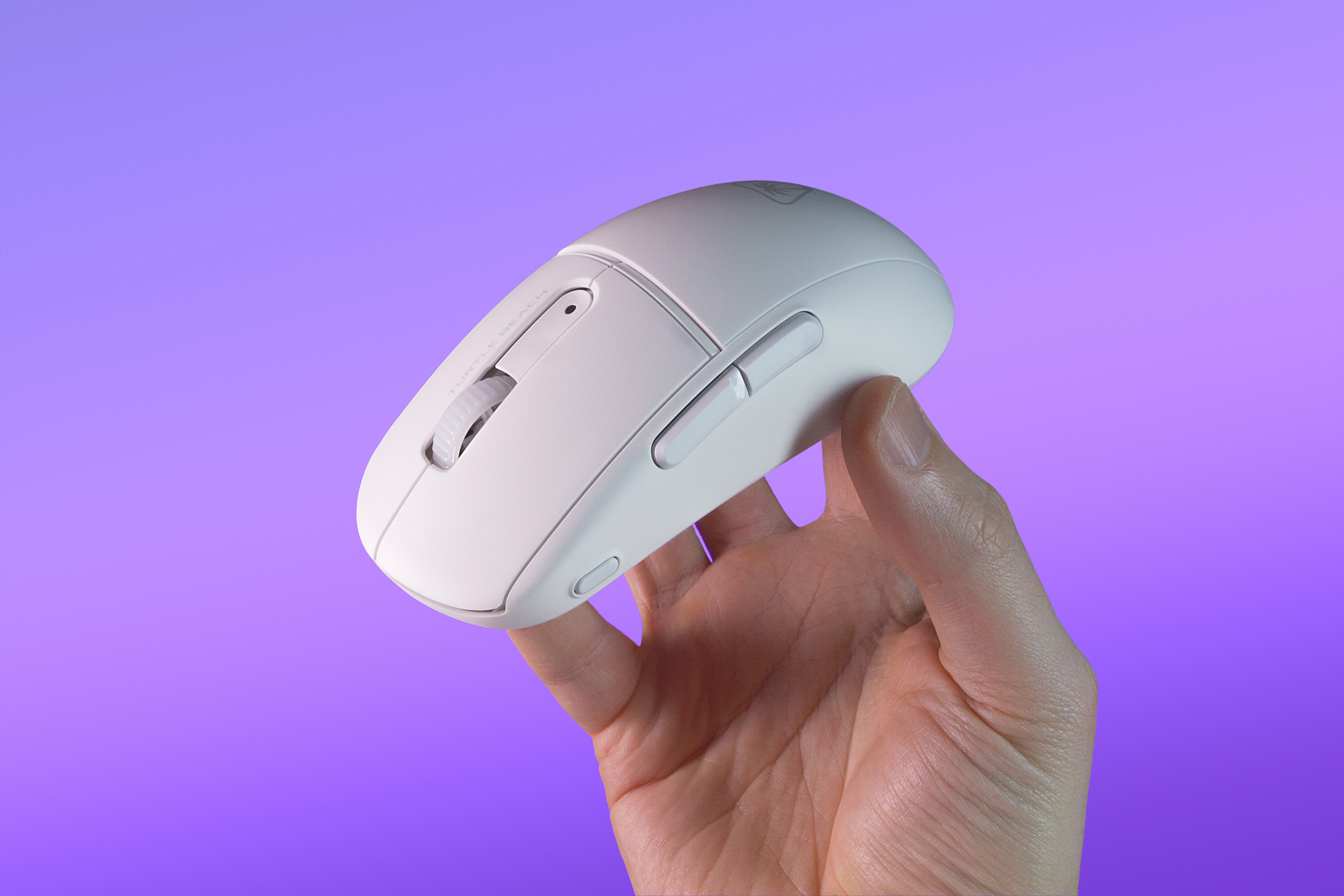 Biała mysz bezprzewodowa trzymana w dłoni, na fioletowo-niebieskim tle gradientowym.
