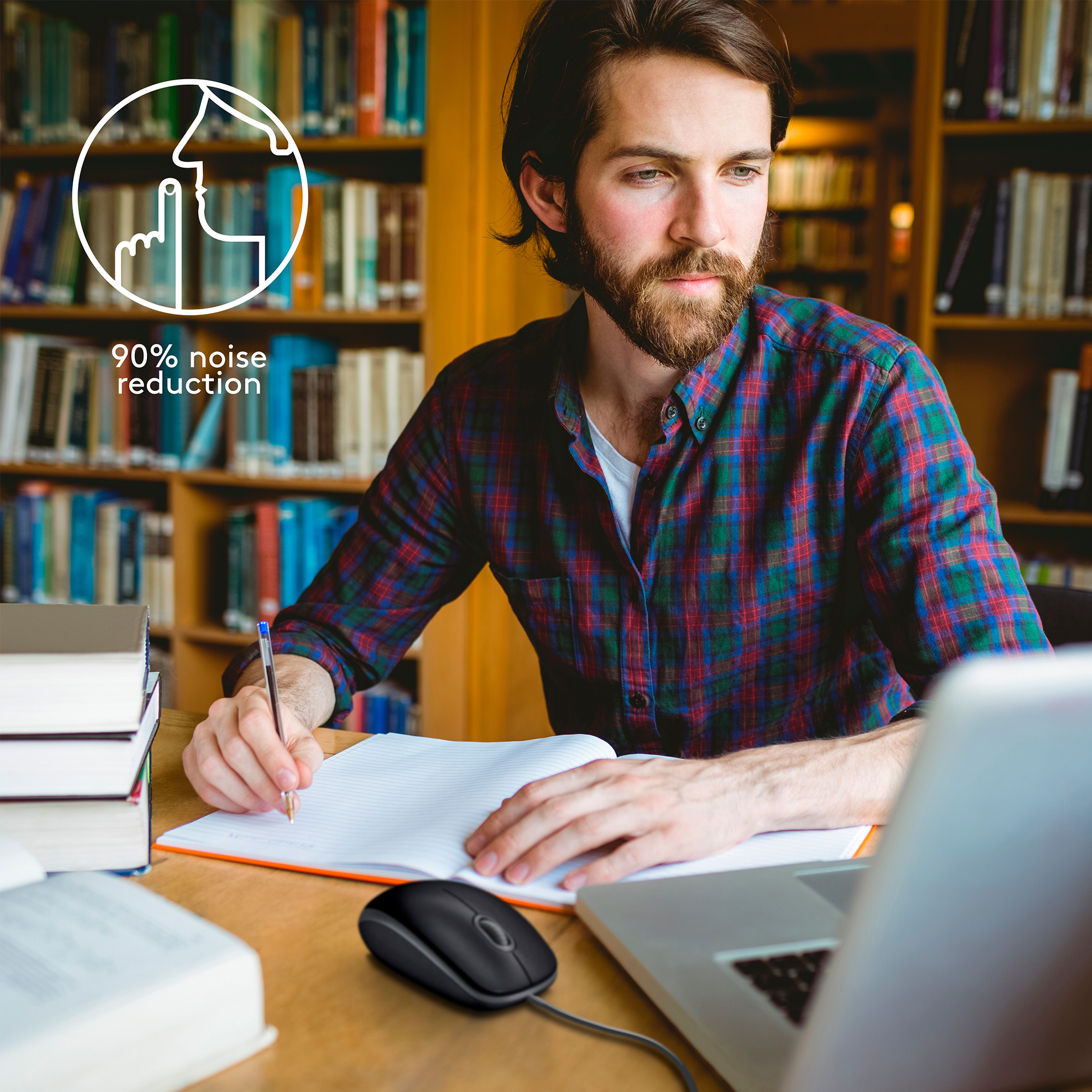 Mężczyzna w bibliotece używający laptopa i myszy z redukcją szumów.