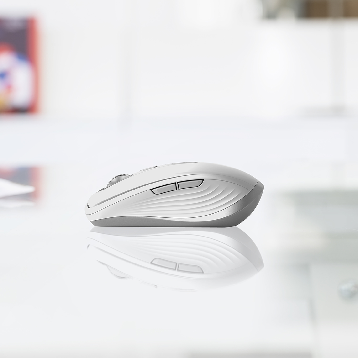 Mouse bianco su superficie riflettente. Due tasti e una rotella visibili.
