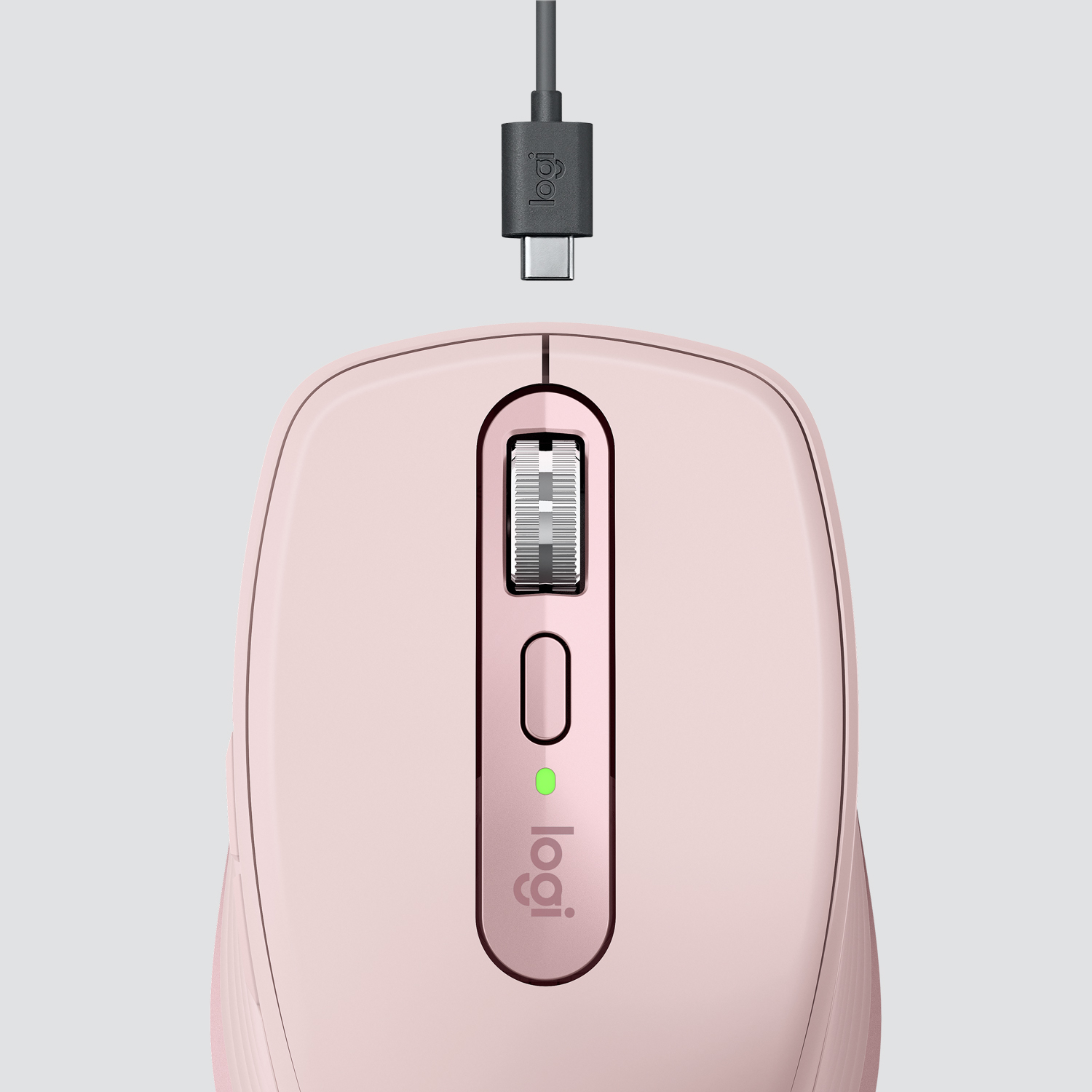 Mouse Logitech rosa con cavo di ricarica collegato sopra. La luce verde si accende. Sfondo bianco.