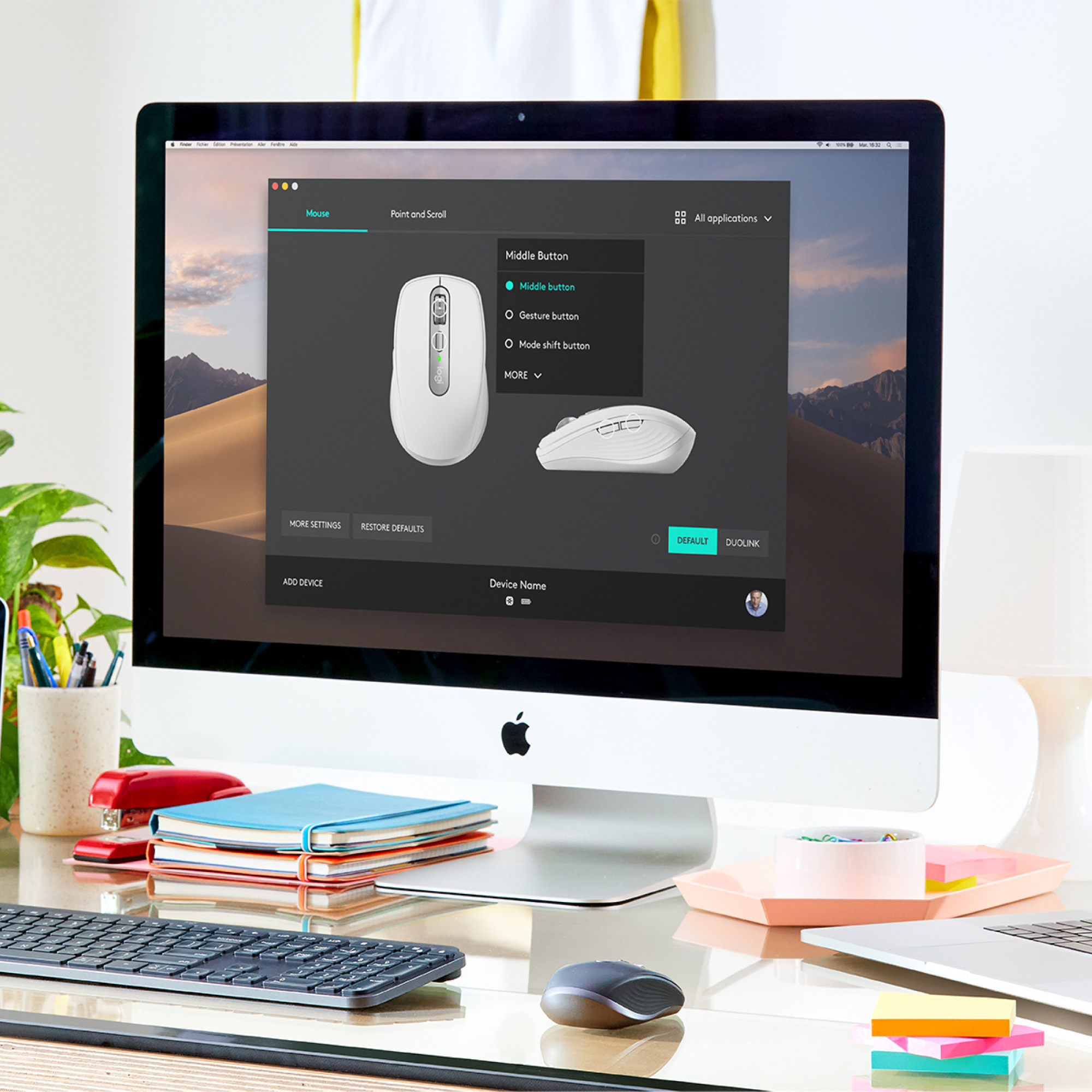 Un iMac muestra una pantalla de configuración del ratón. Un ratón blanco sobre el escritorio.