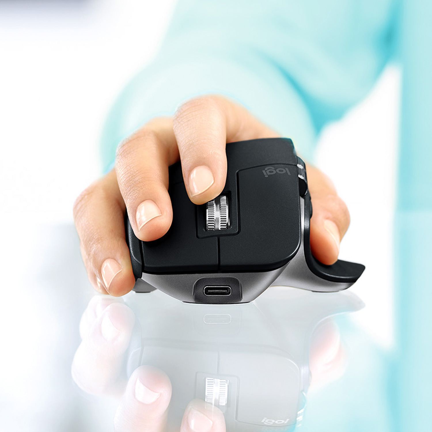 Mano che tiene un mouse nero. Rotella di scorrimento laterale visibile. Porta USB-C sul mouse.