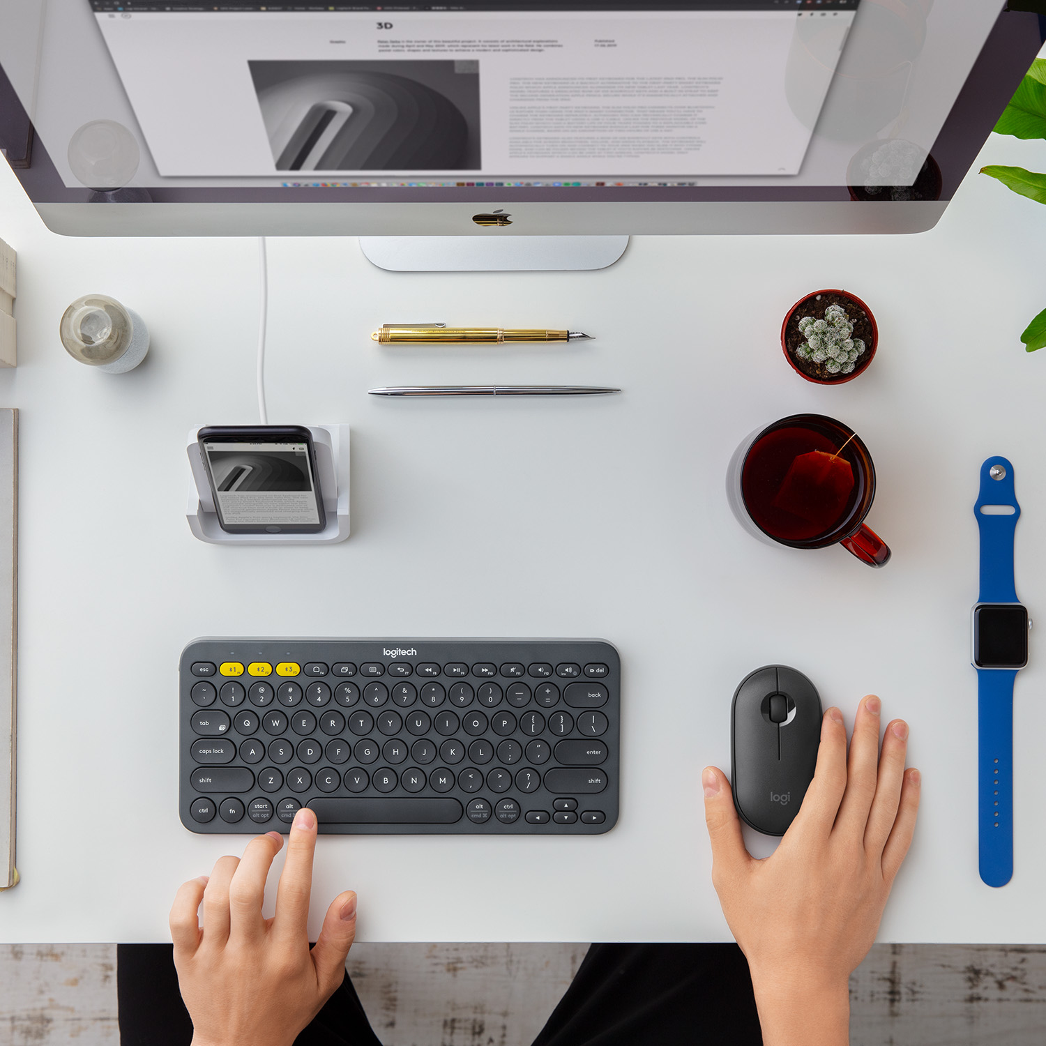 Een bureau toont een toetsenbord, muis, telefoon, koffiekopje en horloge. Een computerscherm staat op de achtergrond.