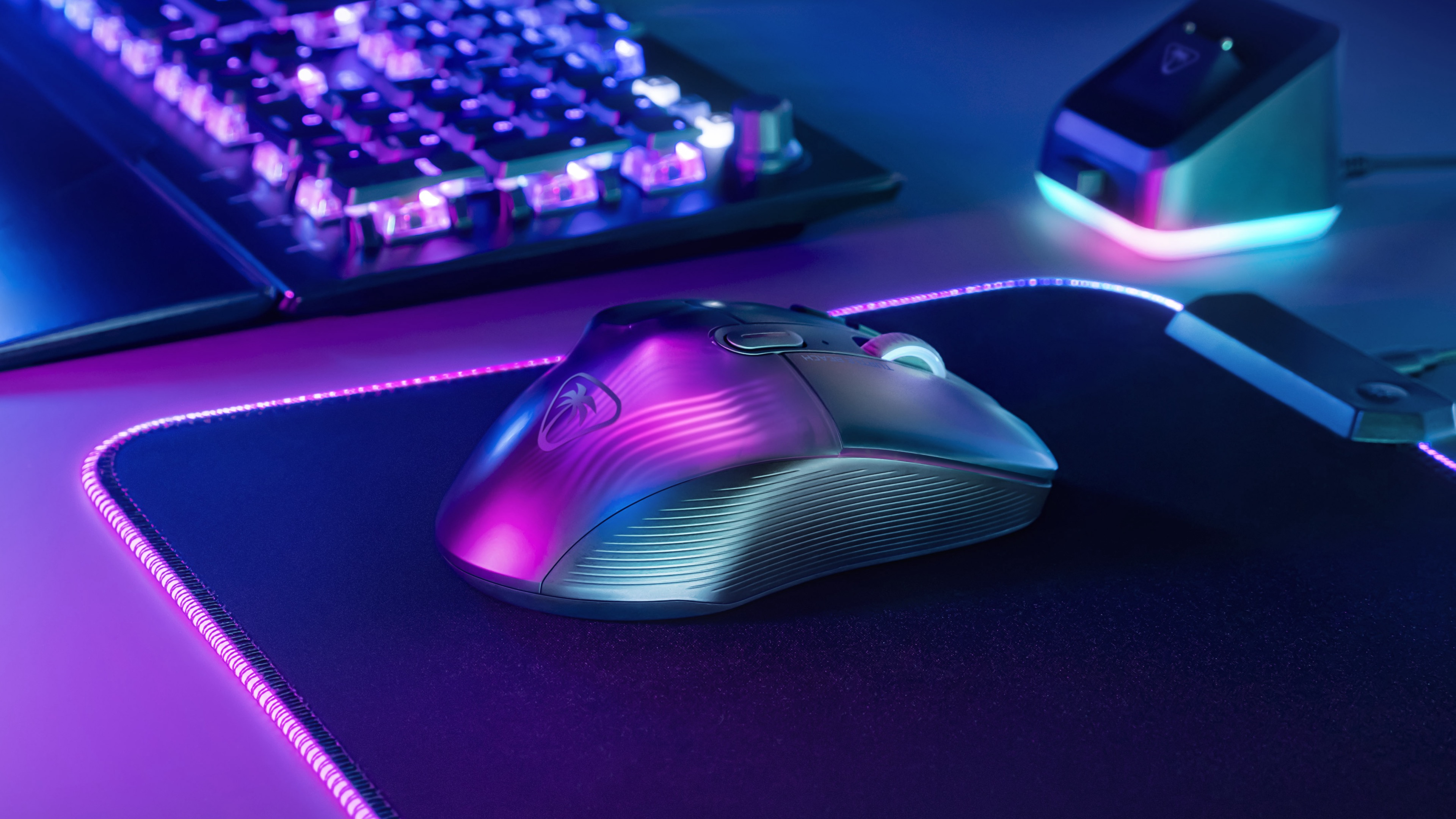Gamingmuis op een muismat. Toetsenbord en een apparaat ook zichtbaar met neonlichten.