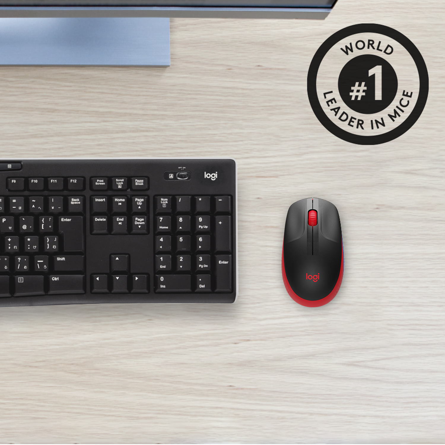 A black keyboard and a red and black mouse on a wooden desk. A logo is visible.