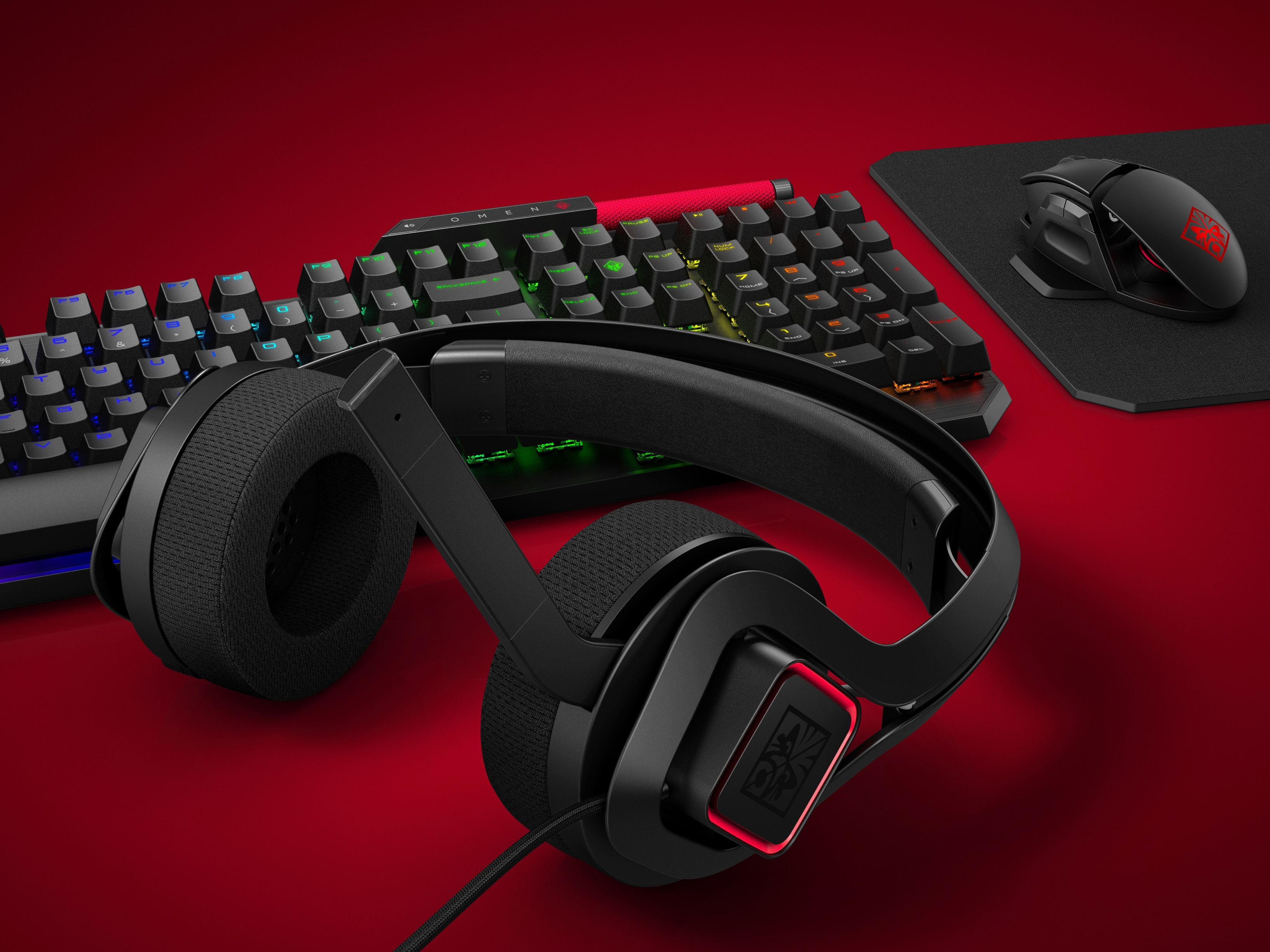 Konfiguracja do gier: klawiatura, zestaw słuchawkowy, mysz i podkładka na czerwonej powierzchni.