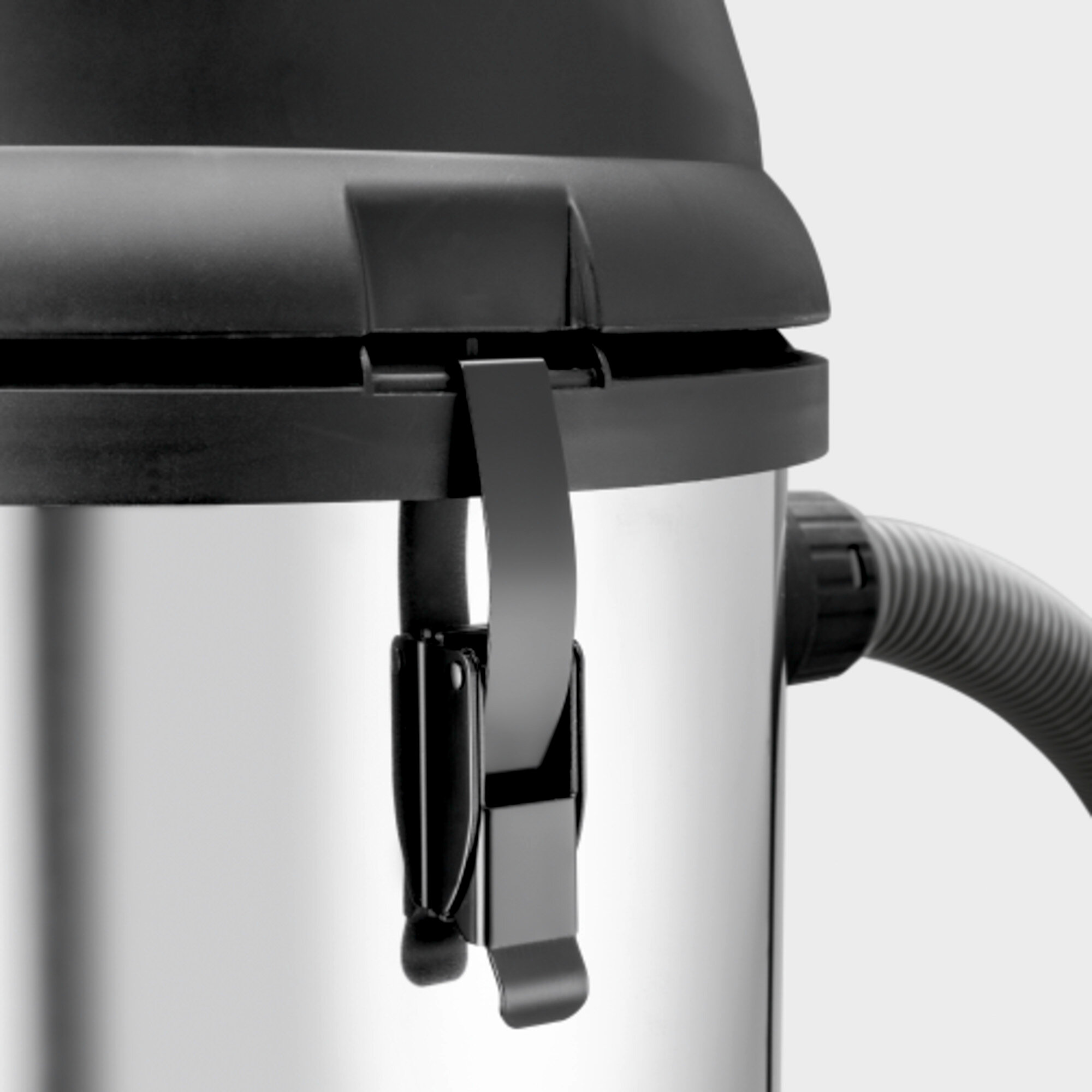 Zbliżenie srebrnego odkurzacza z czarną pokrywą i uchwytem.