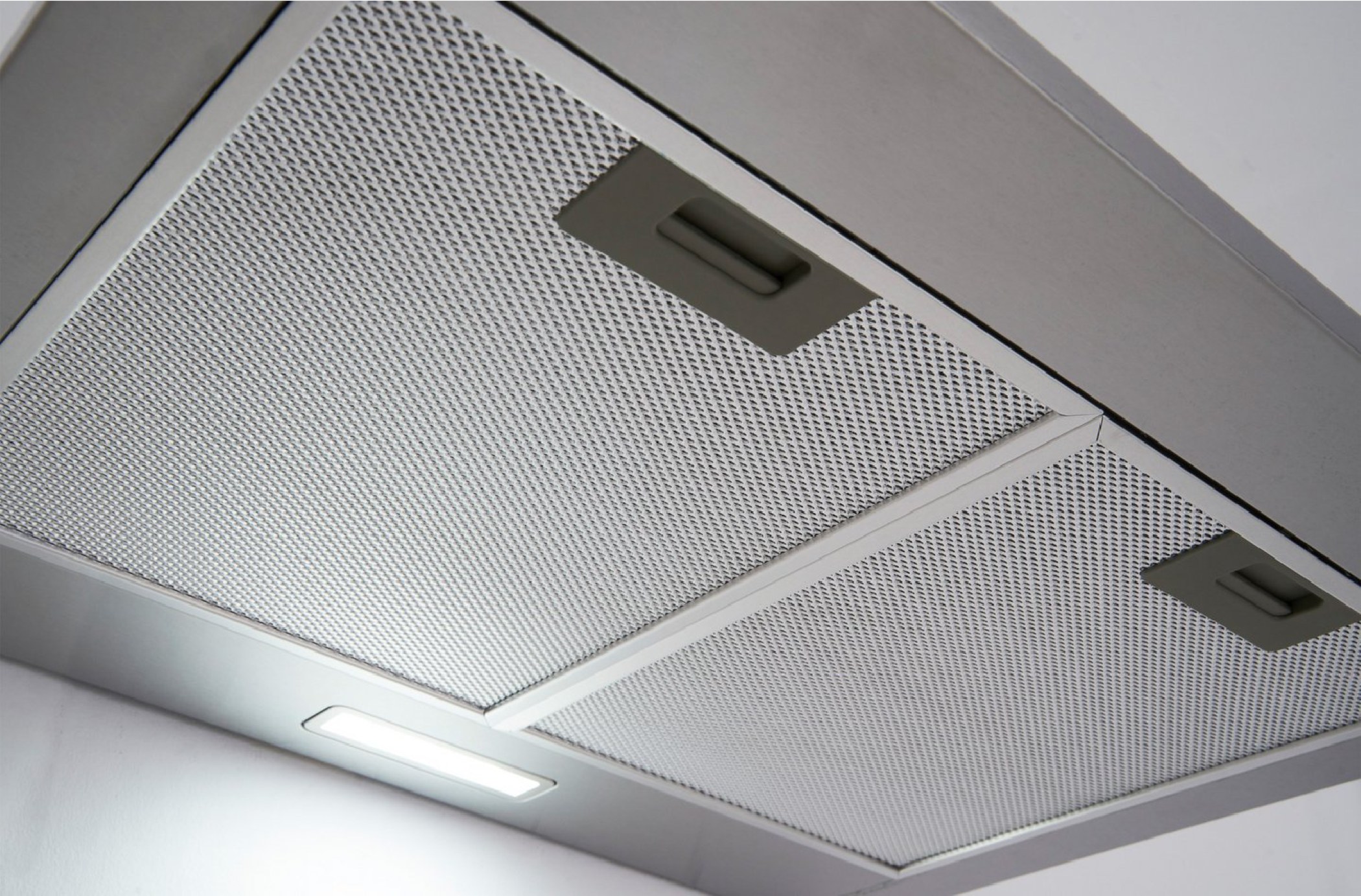 Nahaufnahme eines metallischen Dunstabzugsfilter. Perforiertes Metallgitter mit zwei Griffen.