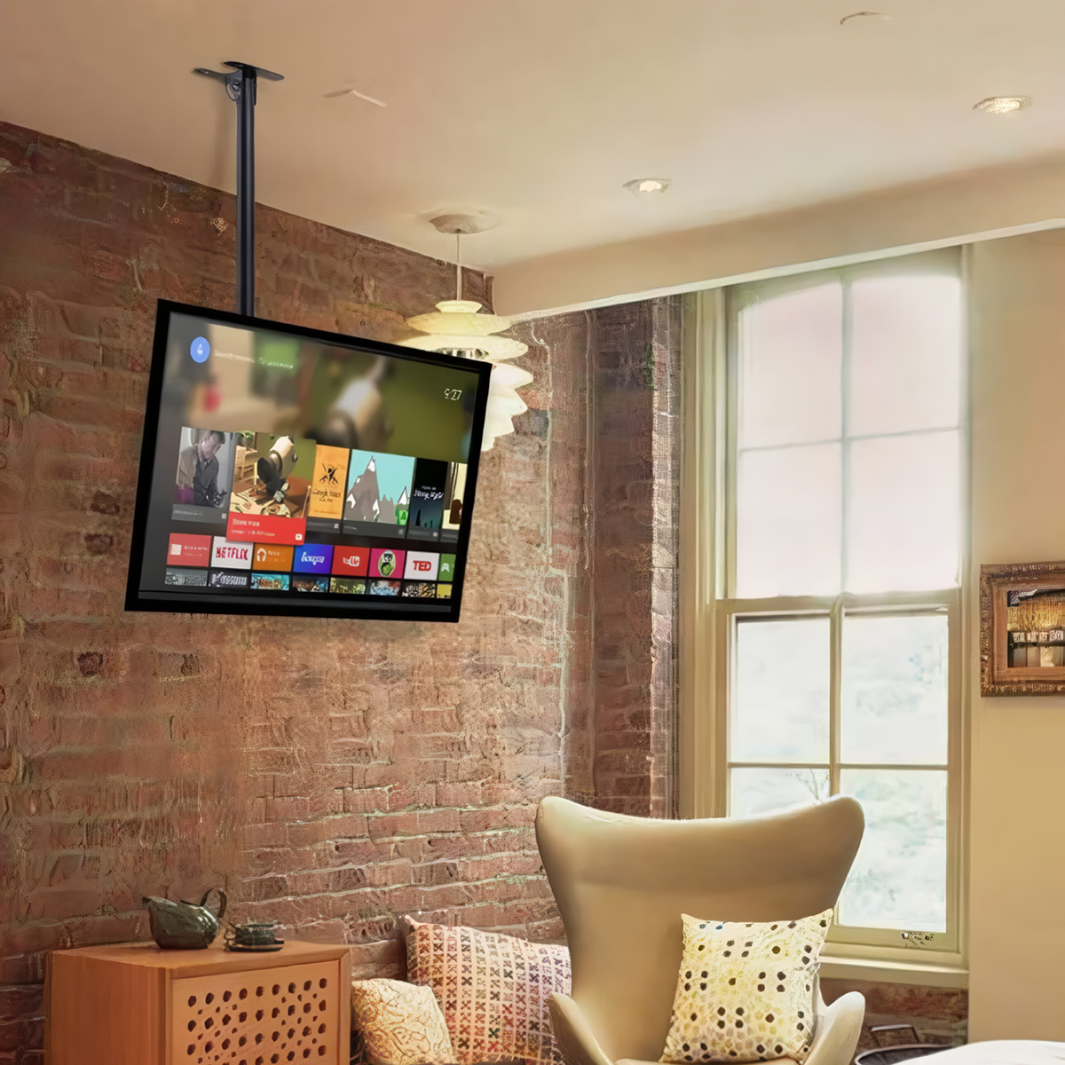 Un televisor montado en una pared de ladrillo. El televisor muestra una interfaz de streaming, con ventana y lámpara.