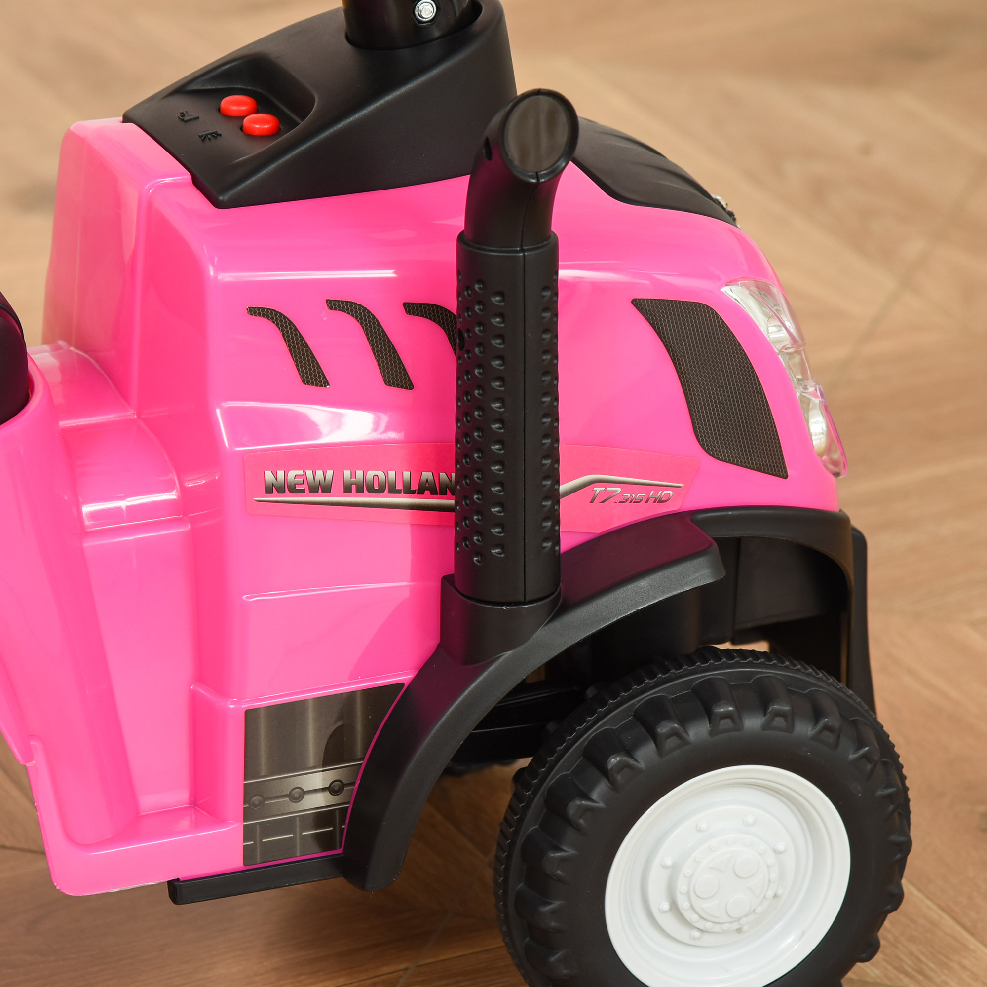 Tractor de juguete rosa. Tiene la marca New Holland y T7.235 HD. Cuenta con tubo de escape negro y rueda blanca.