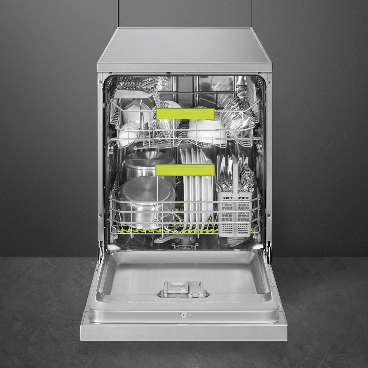 Lavastoviglie con porta aperta, piena di piatti, utensili e un supporto di plastica verde.