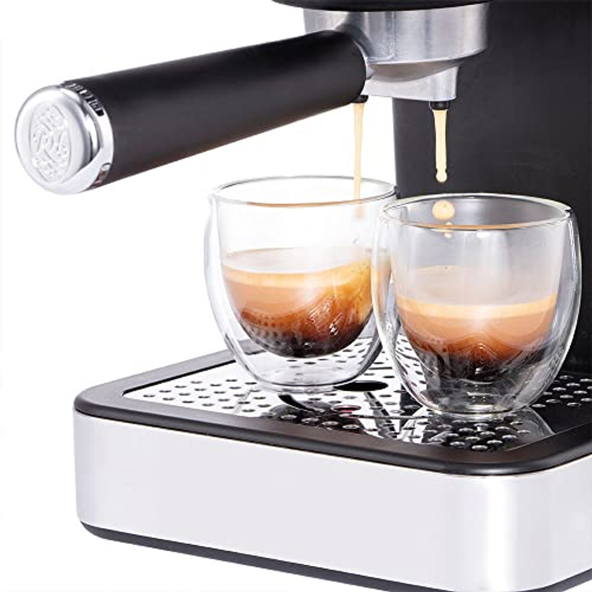 Espressomaschine gießt Kaffee in zwei klare, doppelwandige Gläser auf einem Edelstahlblech.