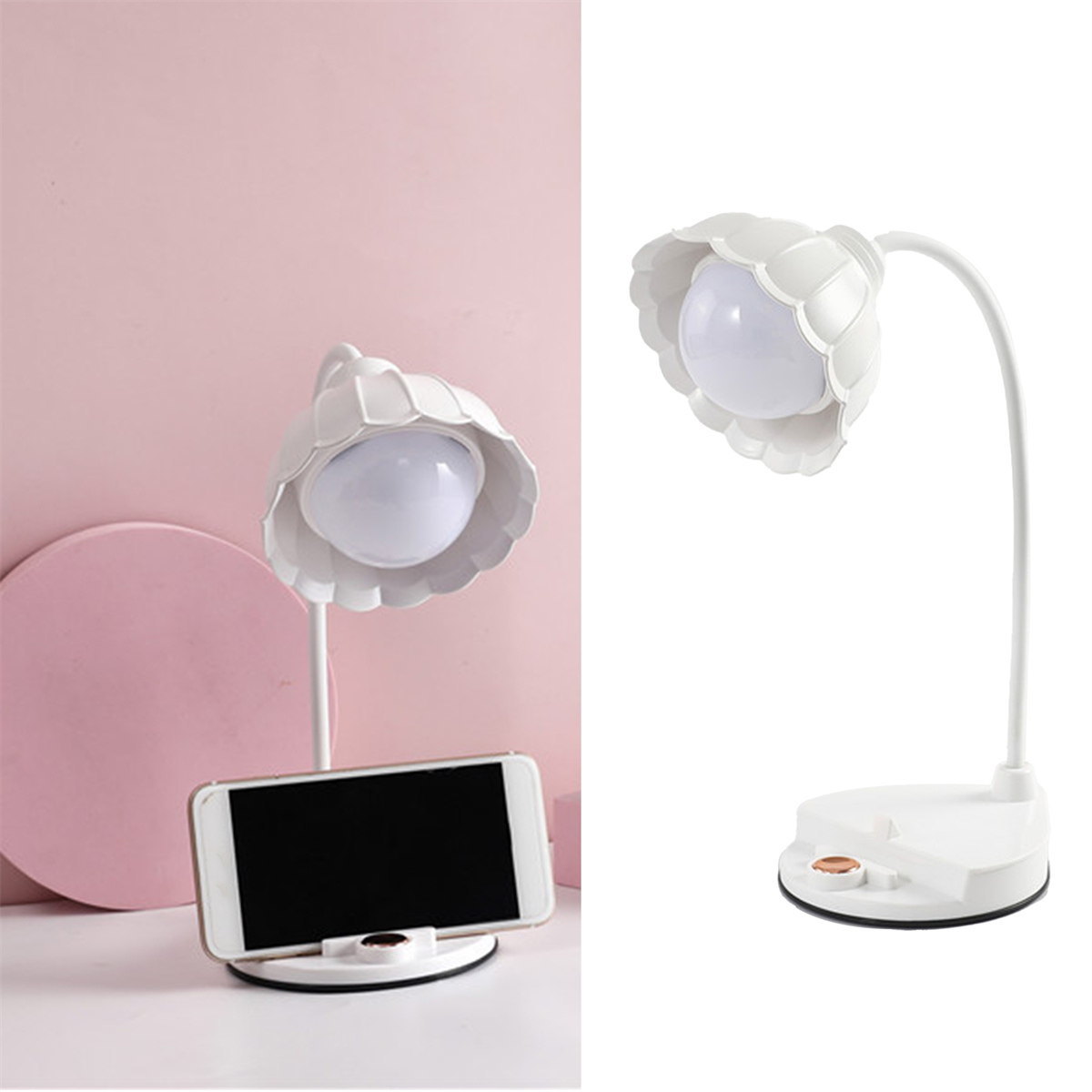 Eine weiße, blütenförmige Schreibtischlampe und ein Smartphone auf einem Schreibtisch. Rosa Wandhintergrund.