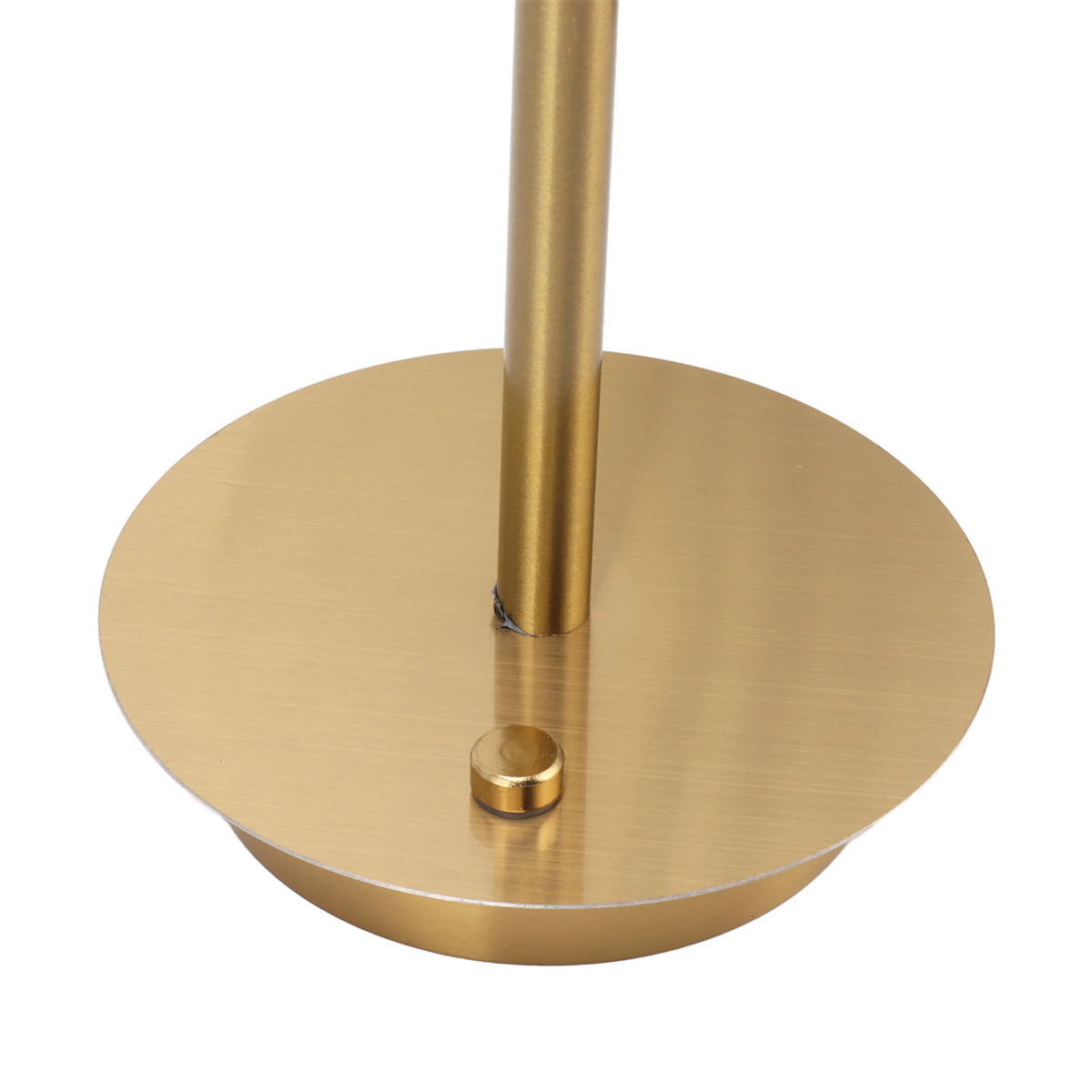 Ein goldfarbener, kreisförmiger Sockel einer Lampe mit einem kleinen Knopf.