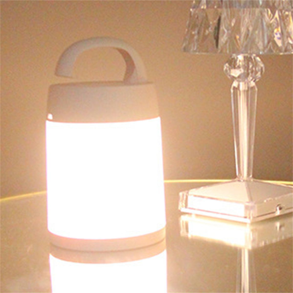 Weiße Laternenlampe.  Weiße Lampe mit Griff, beleuchtet.  Eine Kristalllampe im Hintergrund.  Warmes Licht.