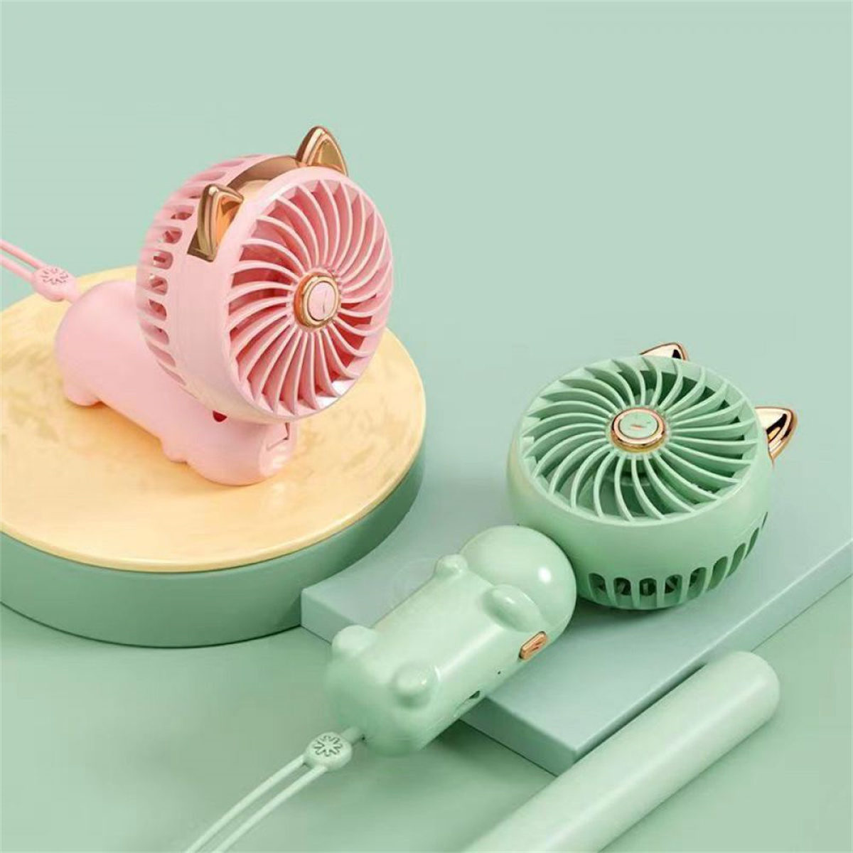 Rosa und grüne katzenförmige Ventilatoren auf einer grün-gelben Oberfläche.