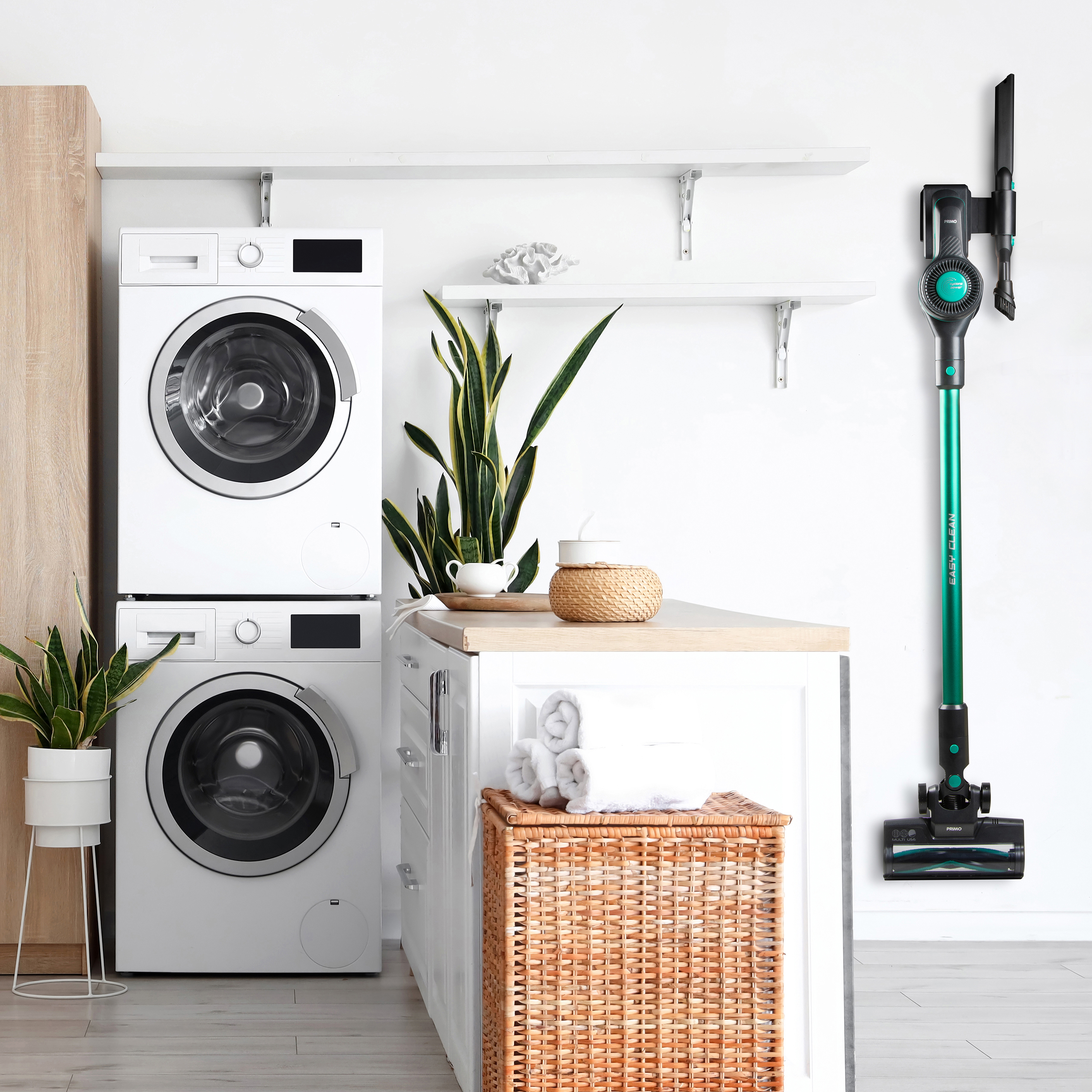 A modern laundry room with a washing machine, dryer, and a vacuum cleaner. White and green colors.