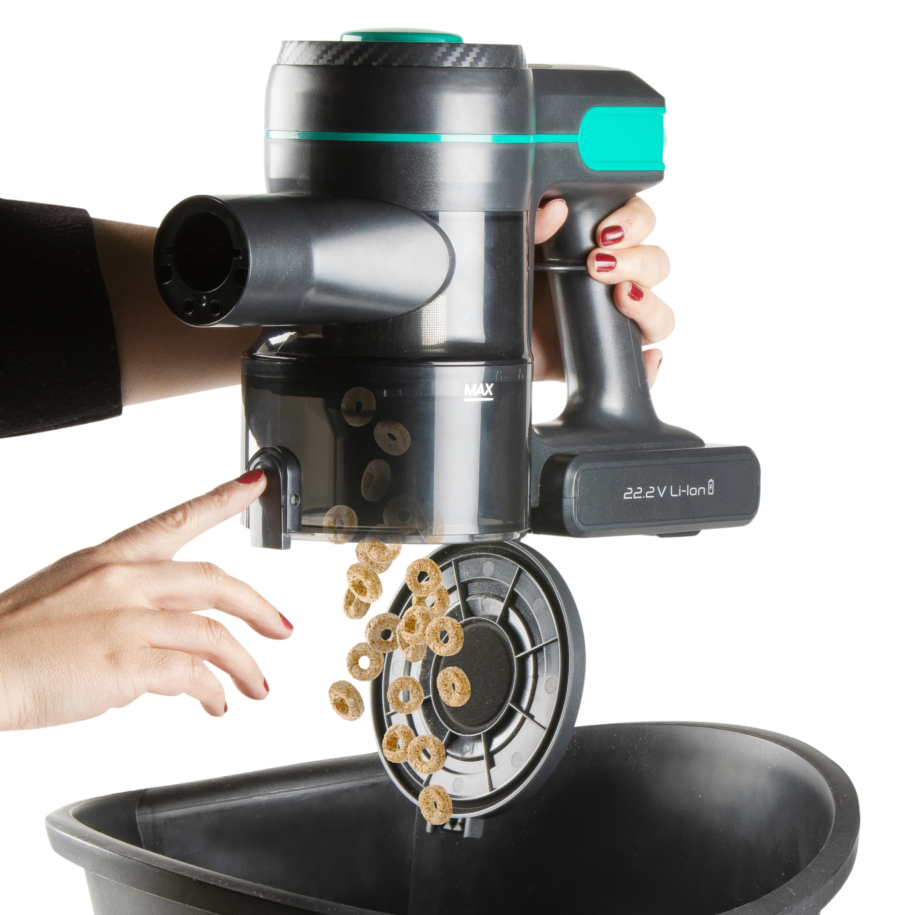 Hand holding a vacuum cleaner. Cereal is pouring into a black container.