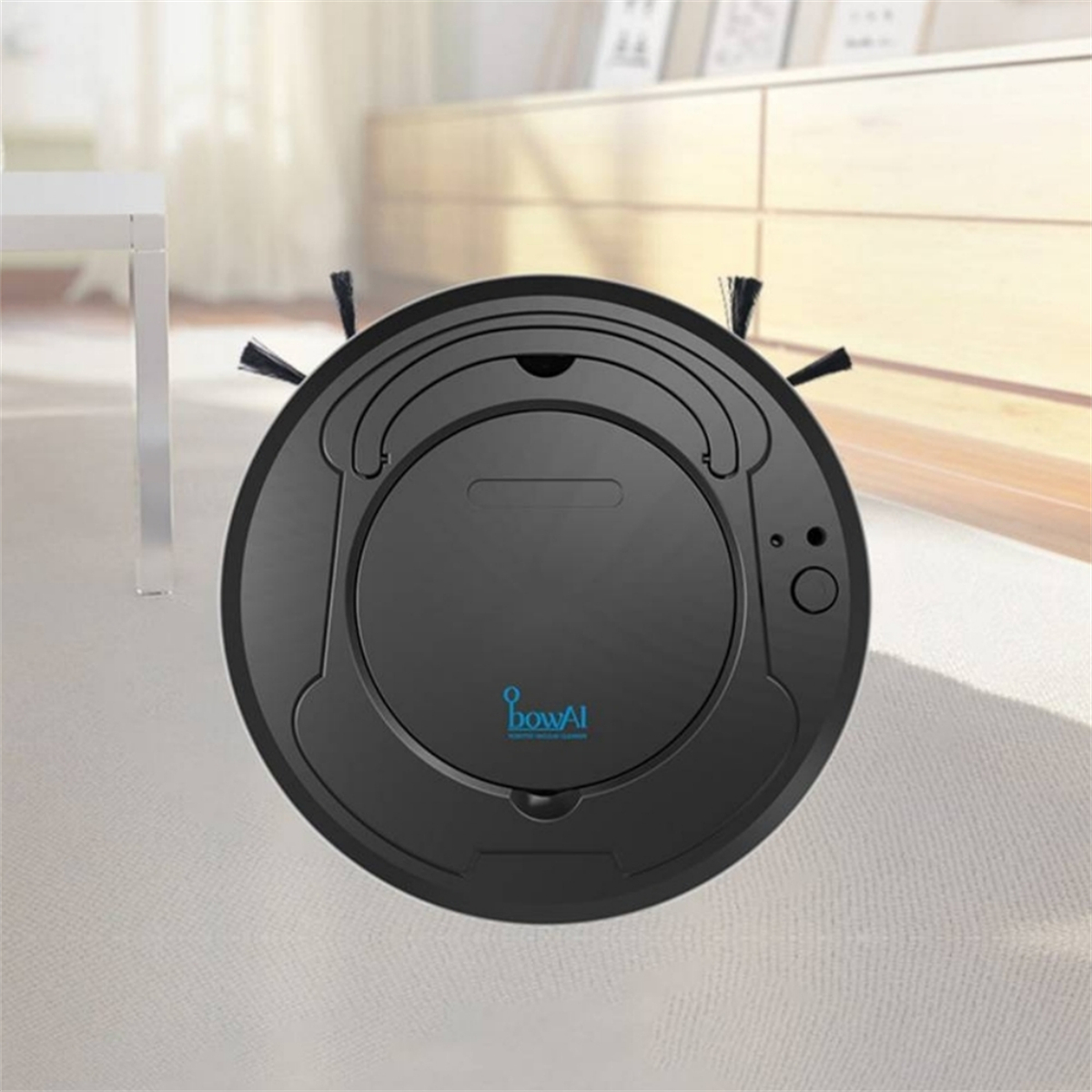 Ein schwarzer Roboter-Staubsauger auf einem Teppich, mit einem weißen Schrank im Hintergrund.