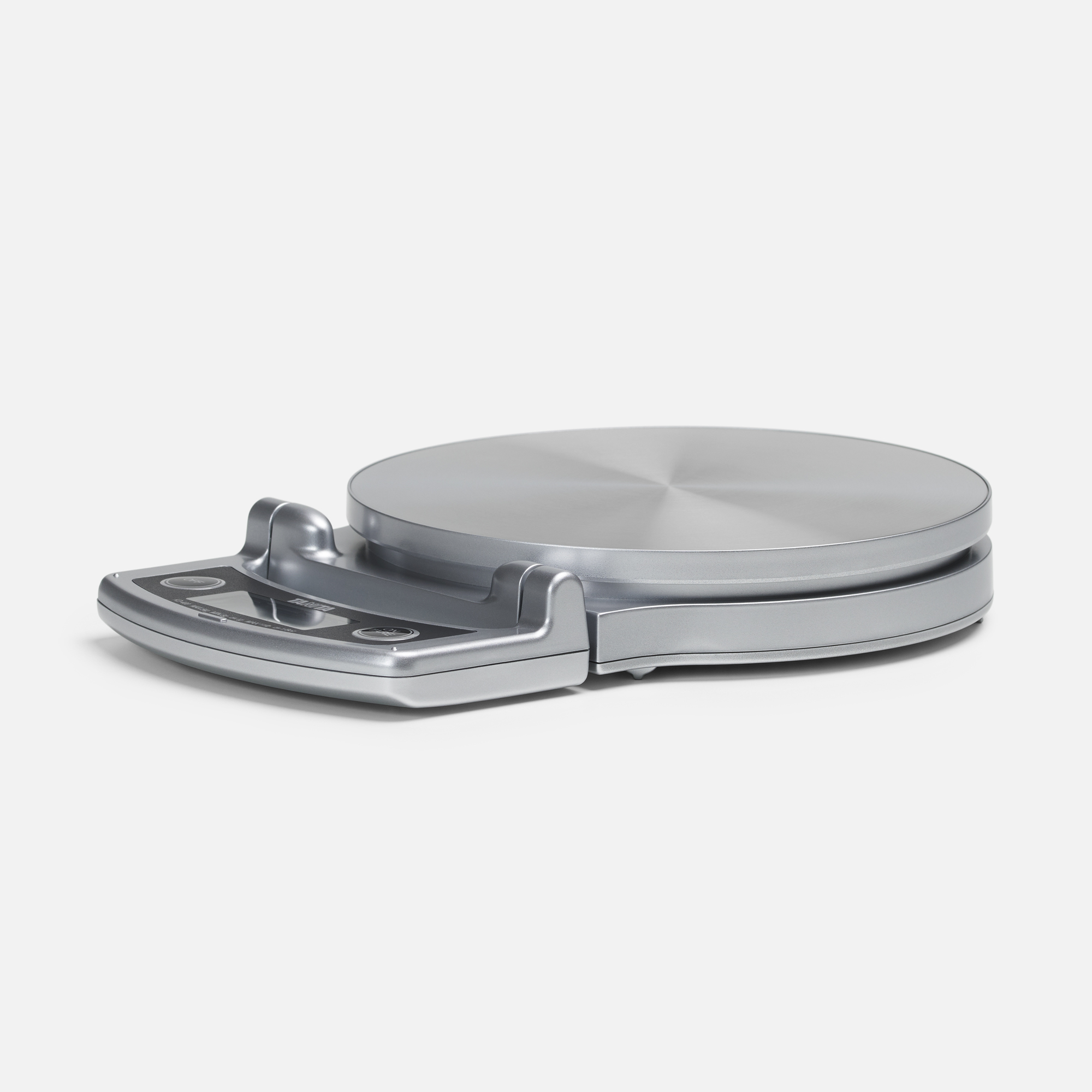 A silver digital kitchen scale with a round surface and a control panel on the front.