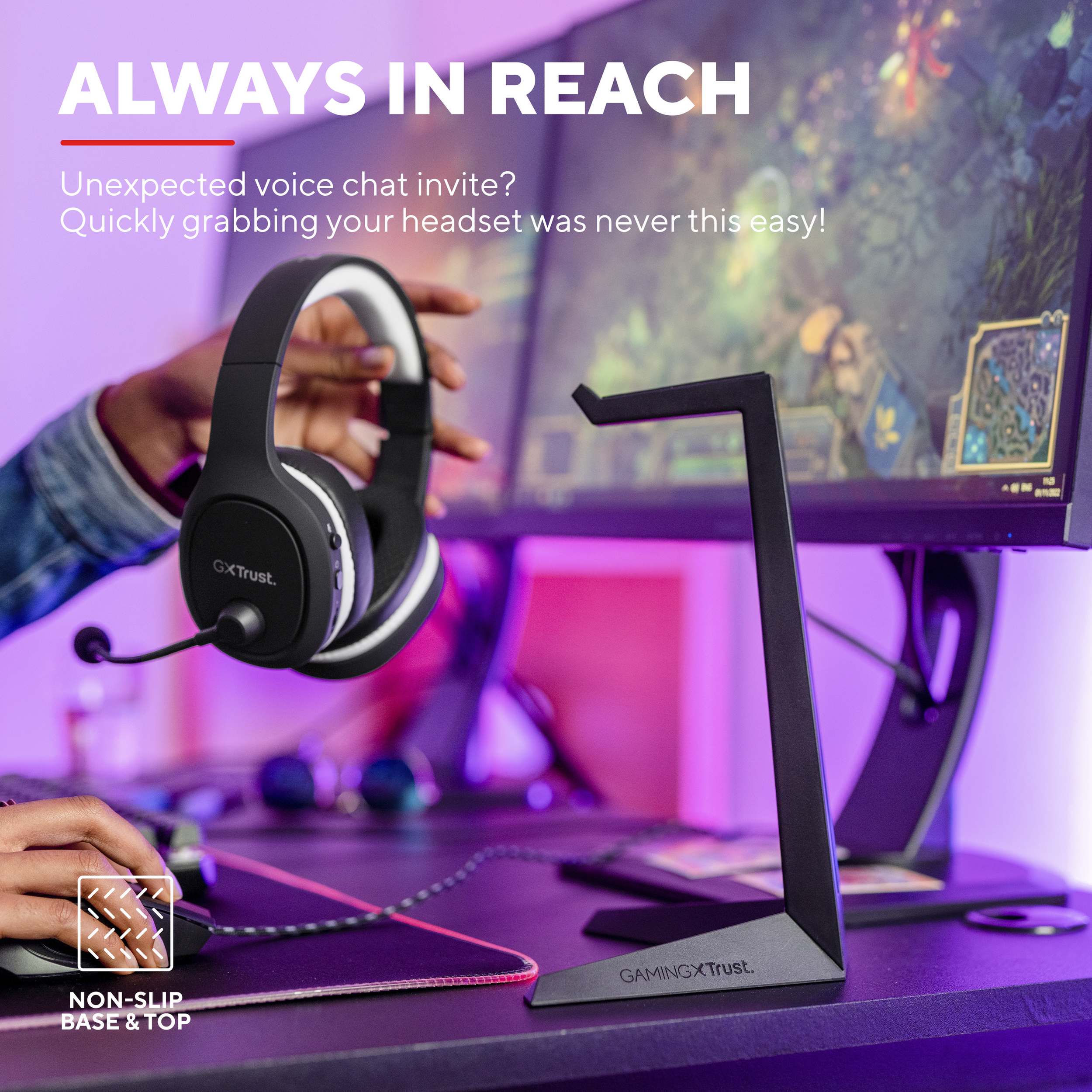 Headset en standaard op bureau. Hand reikt naar headset. Computerscherm zichtbaar.