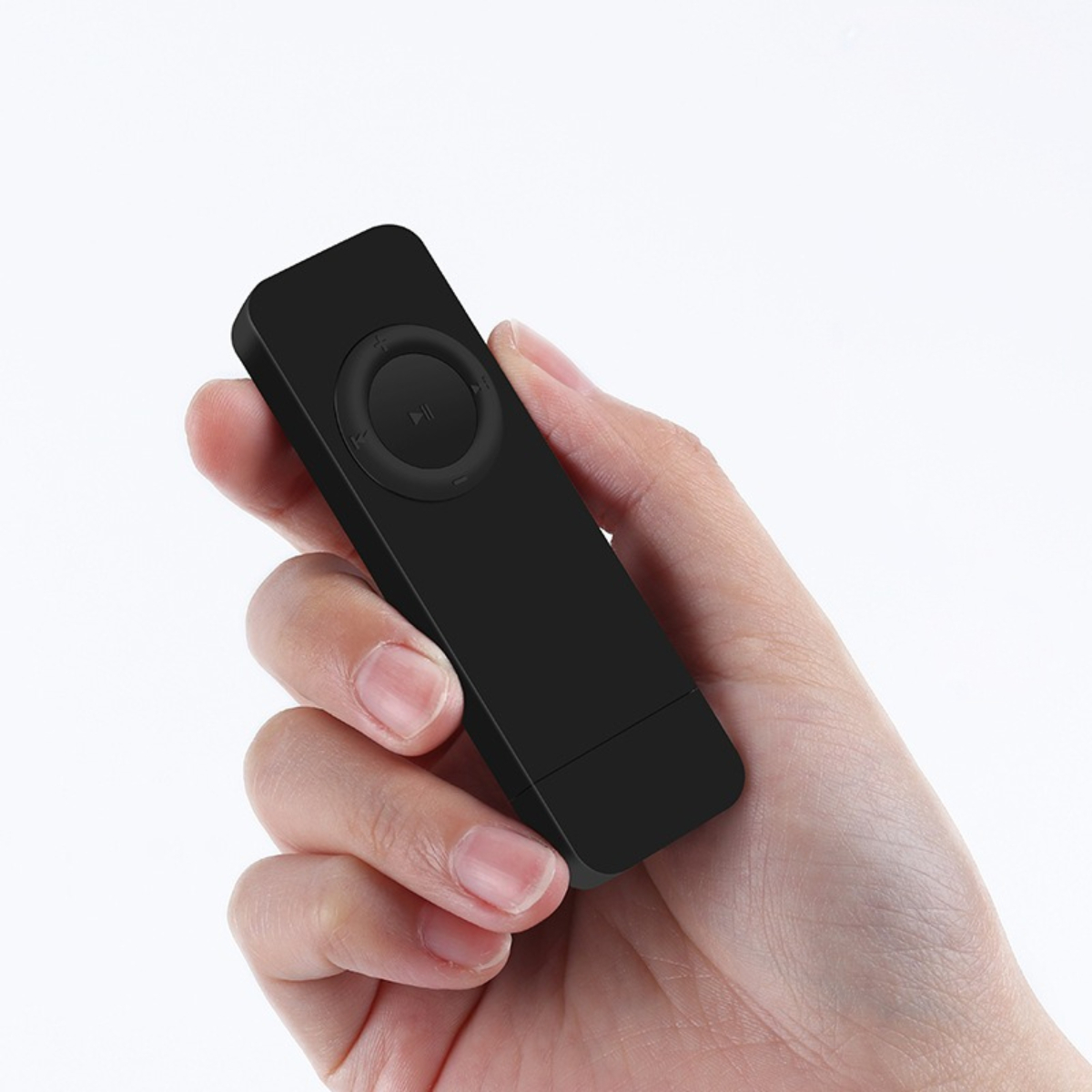 Ein schwarzer, rechteckiger MP3-Player in einer Hand. Er hat einen zentralen Knopf.