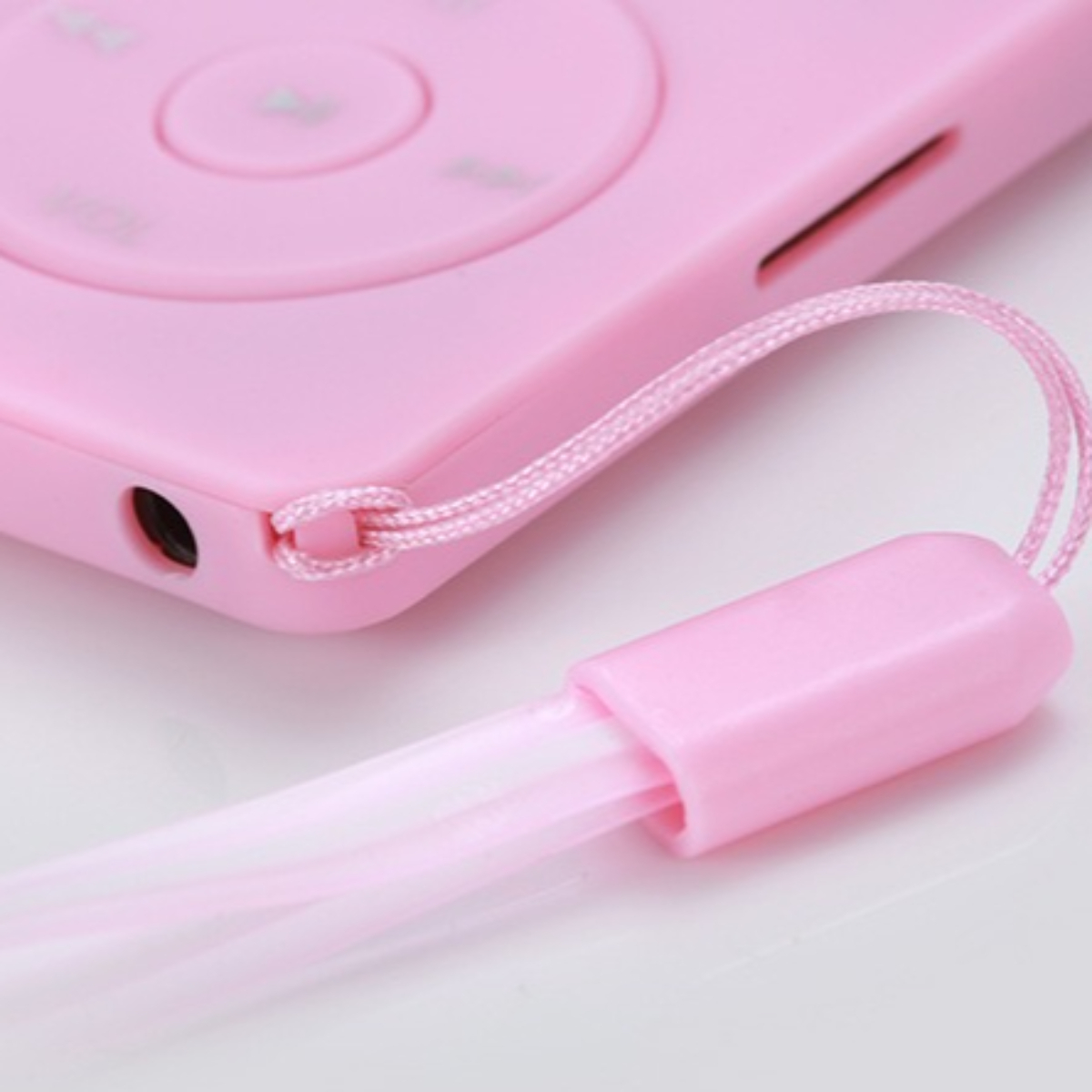 Nahaufnahme eines rosa MP3-Players mit rosa Band auf Weiß.