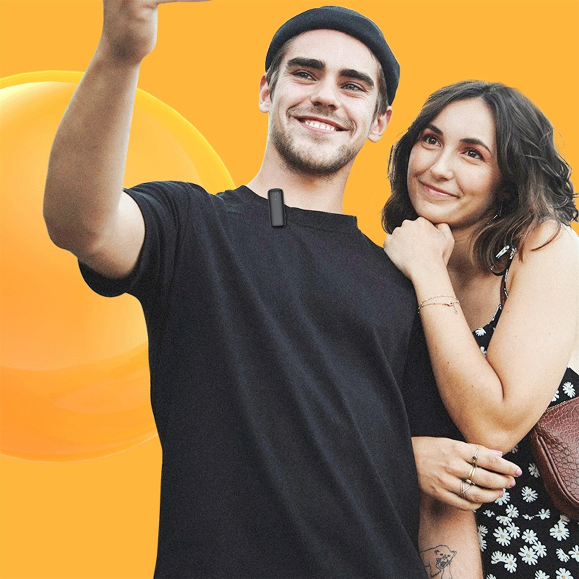Ein Mann macht ein Selfie mit einer Frau. Der Mann trägt ein schwarzes T-Shirt und eine Mütze. Die Frau hat ein Blumenkleid.
