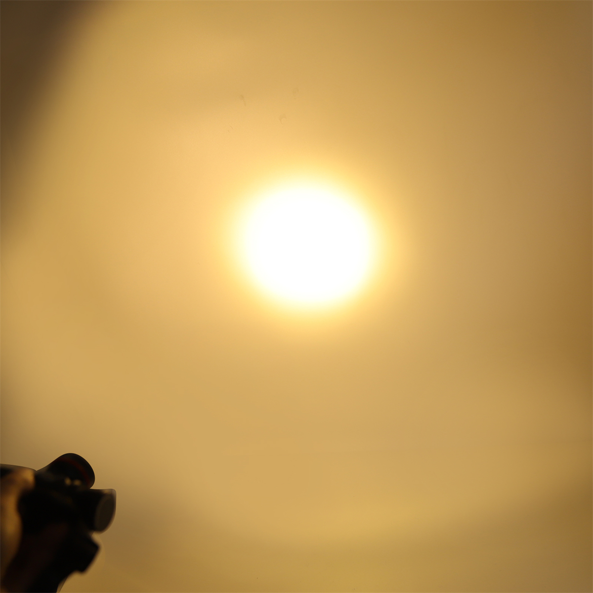 Helles gelbes Licht von einer Taschenlampe. Eine Hand hält das Gerät. Der Hintergrund ist ein gelber Farbverlauf.