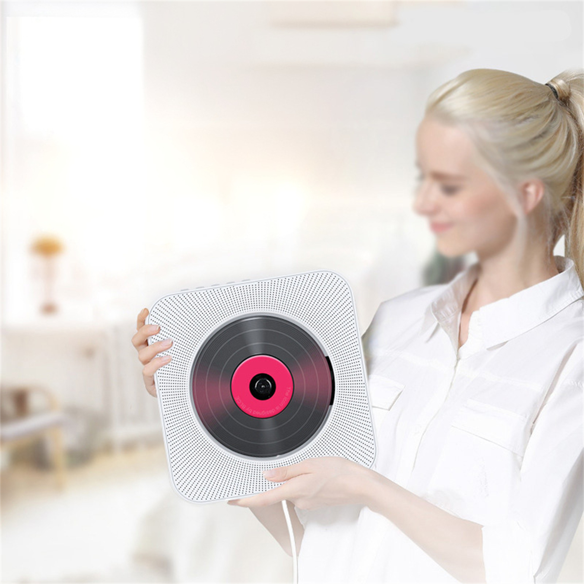Frau hält weißen CD-Player im Retro-Stil. Eine Vinyl-ähnliche Disc ist sichtbar.