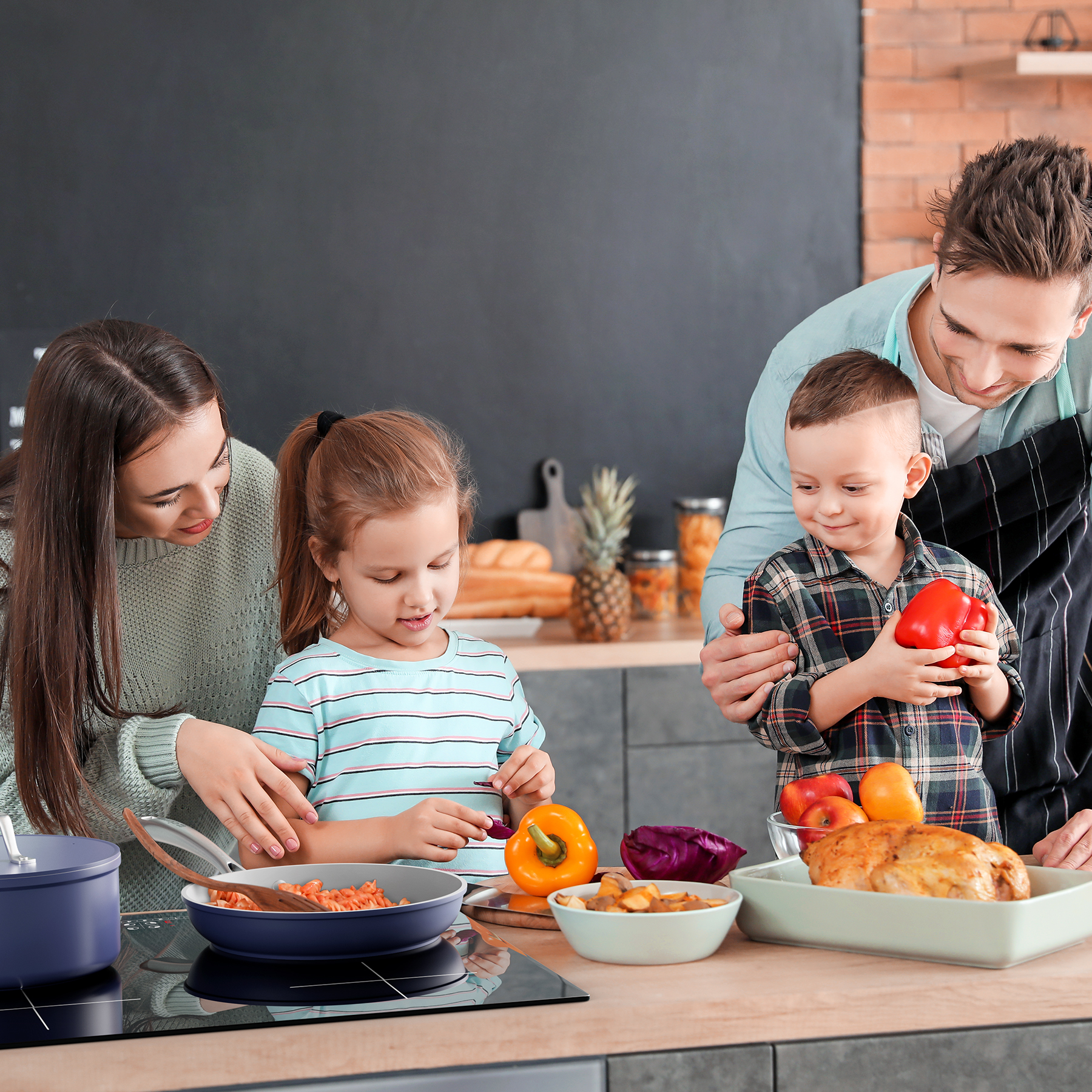 Familie kocht gemeinsam in einer Küche. Beinhaltet Kinder, Eltern und die Zubereitung von Speisen.