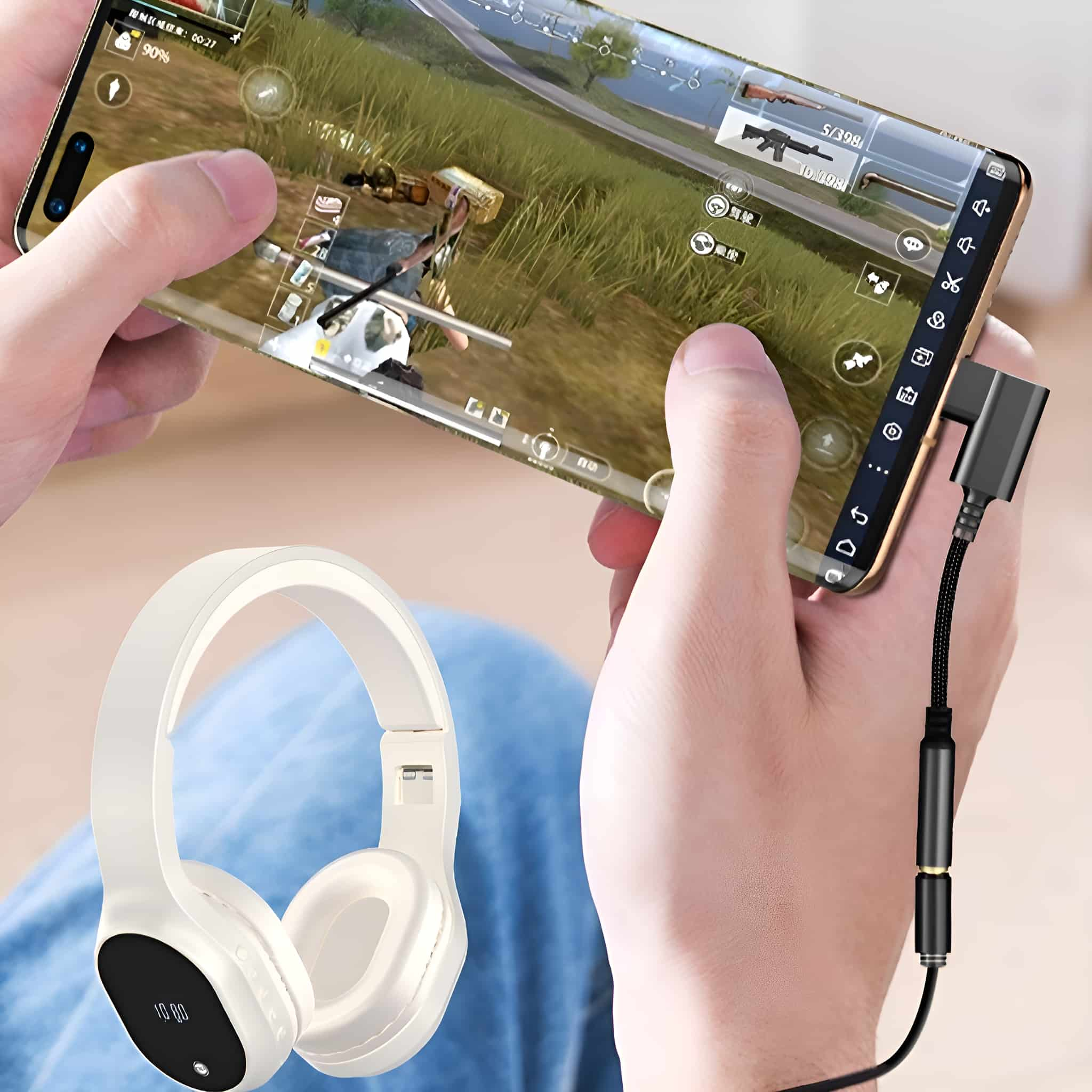 Hände spielen ein Handyspiel mit einem Telefon und weißen Kopfhörern. Ein USB-C-Adapter ist an das Telefon angeschlossen.