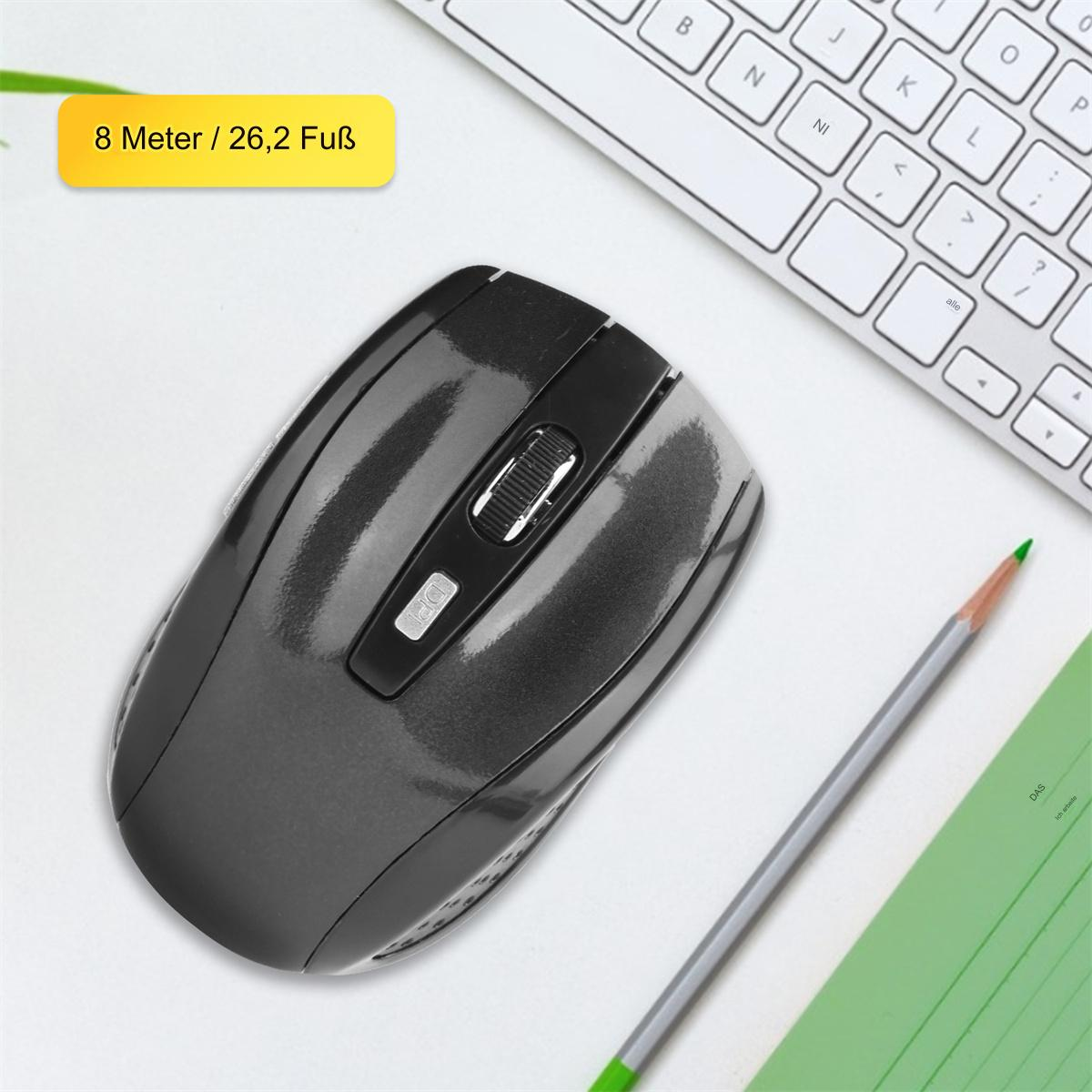 Graue kabellose Maus mit Scrollrad auf einer weißen Oberfläche. Ein Bleistift und eine Tastatur sind im Hintergrund.
