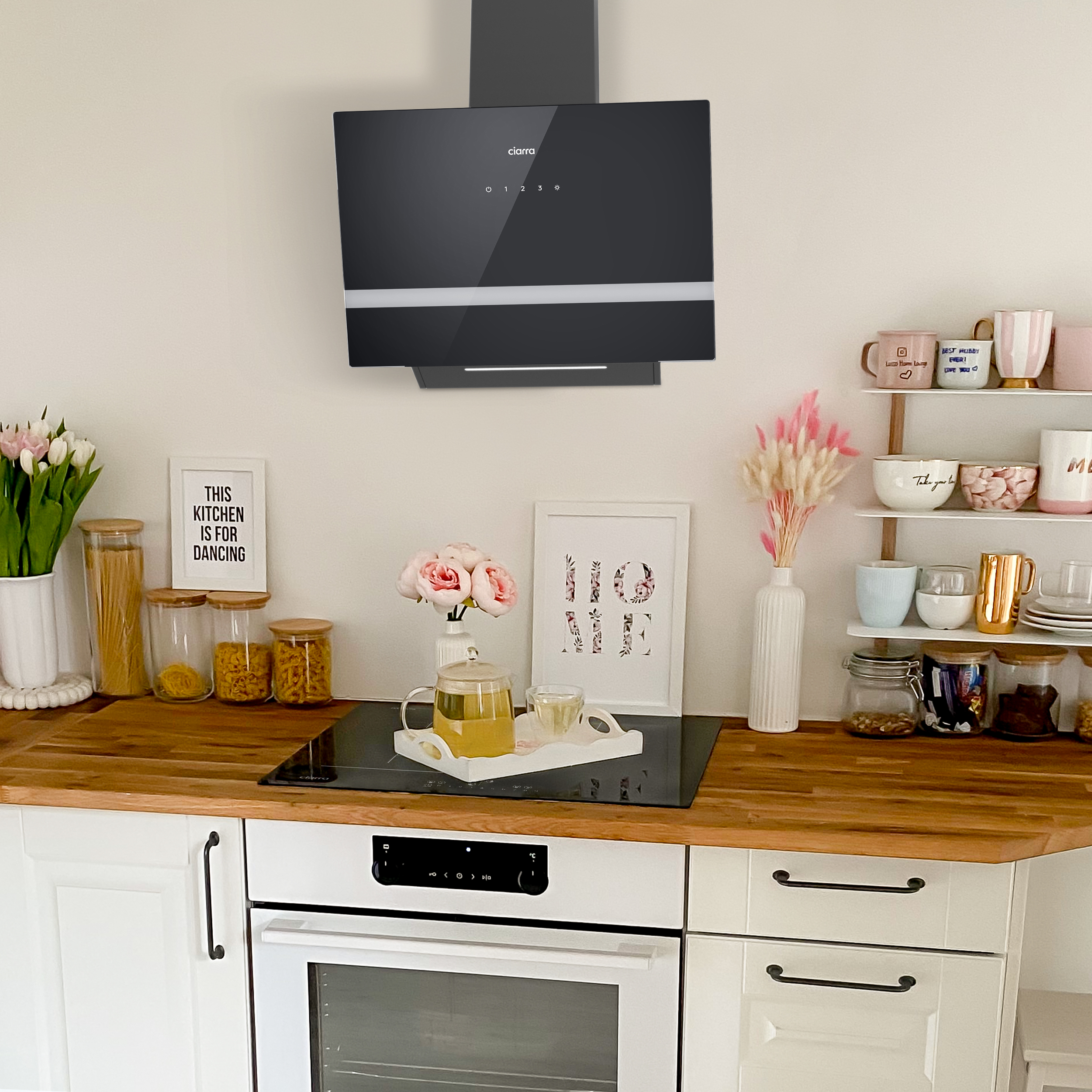 Kitchen interior with a hood, countertop, and decorative items.