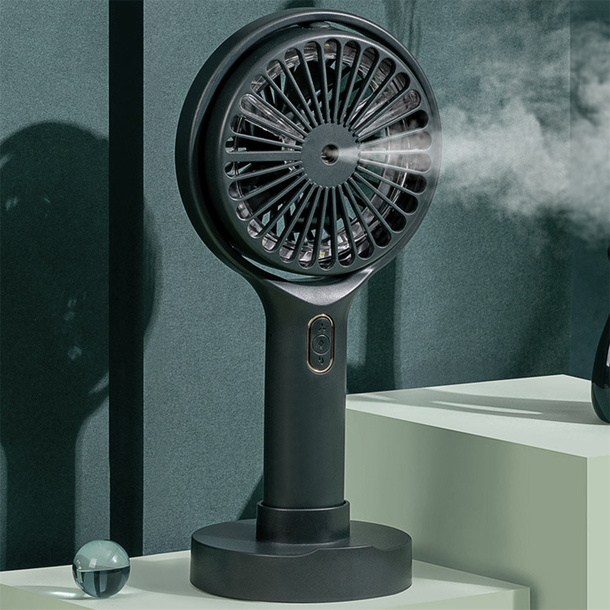 Dunkler Ventilator auf Ständer. Wasserdampf. Grüner Hintergrund. Runde Form.
